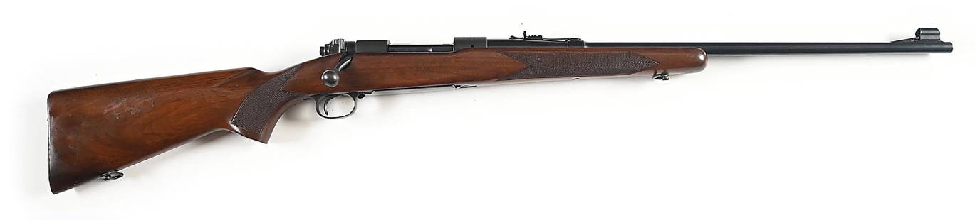 (C) PRE-64 WINCHESTER MODEL 70 BOLT ACTION RIFLE IN 7MM.: Manufactured in 1951. This caliber was one of the 18 standard calibers and was catalogued from 1937-49, making it a special order in 1951. Standard features are post war safety, blue finish, hooded ra