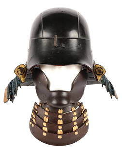 KABUTO AFTER IKEDA HIMENO WITH HANBO: Of zunari construction with a deep brown lacquer, with a two prong slot for a maedate; one prong damaged. Shikoro with four hanging lames with tightly woven blue cord and gilding with a single lame bo