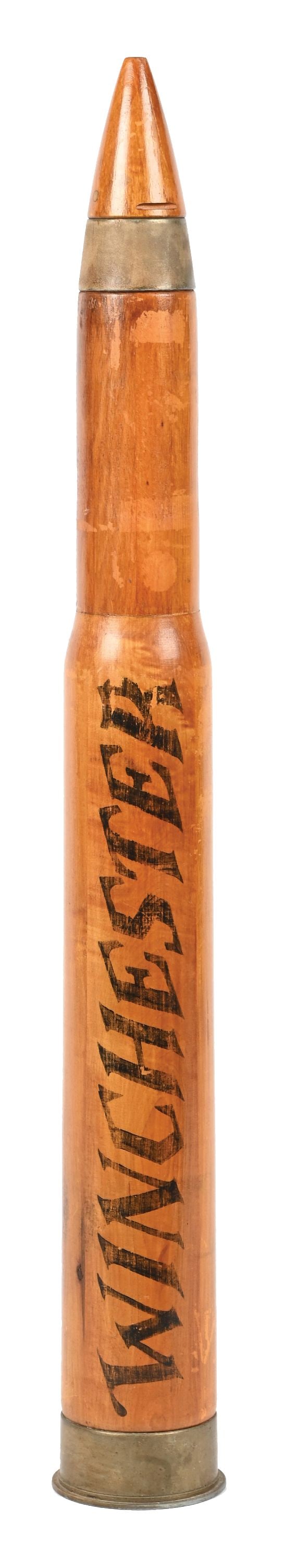 WINCHESTER WOODEN BULLET FIGURAL ADVERTISING: CONDITION: Figural advertising for Winchester Ammunition. A great form with 90% of the original lettering. Areas of wear from use, light scuffs and age cracks. Condition: (Very Good). Dimensions: 35" 