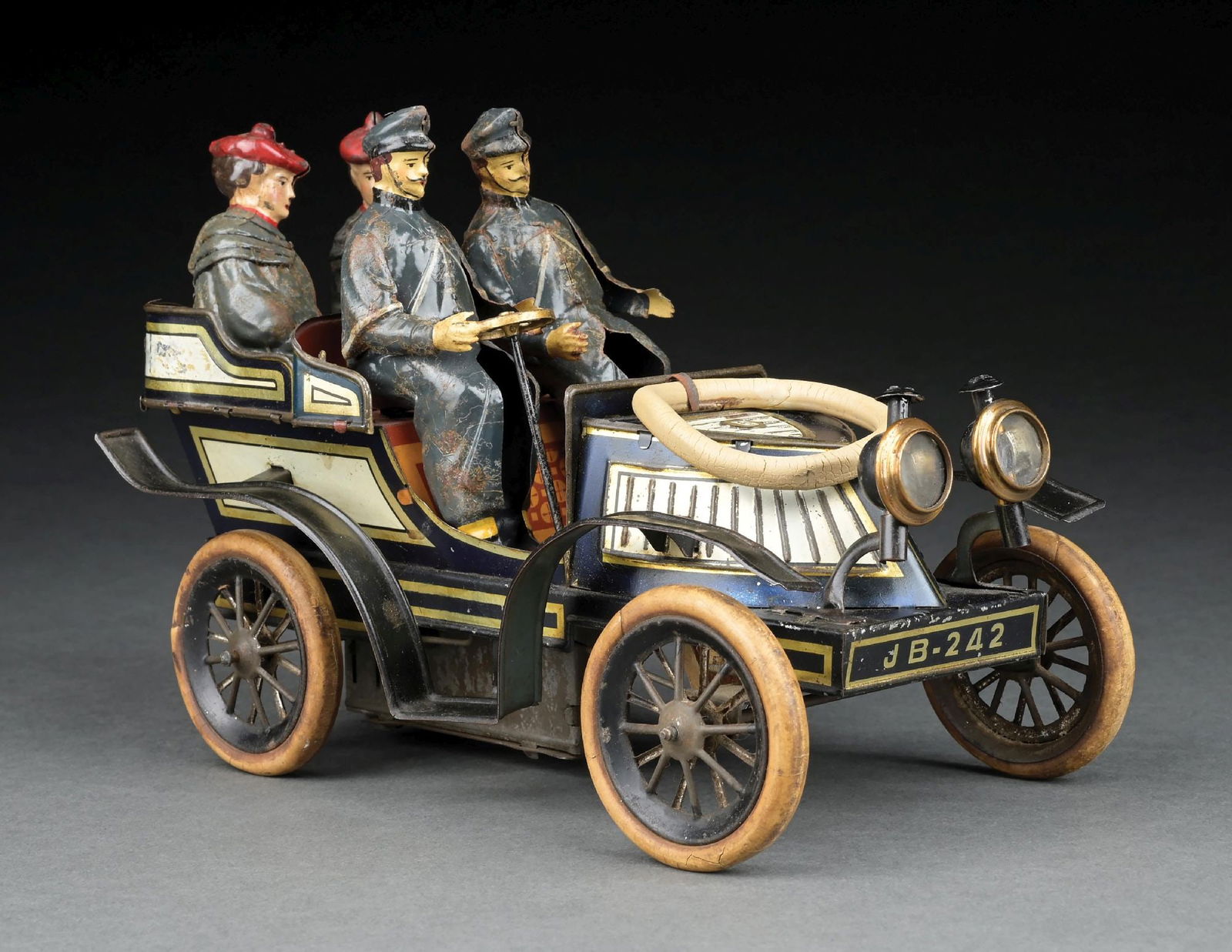 RARE GERMAN GUNTHERMANN TIN LITHO CLOCKWORK BONNET-FRONT AUTOMOBILE: Blue and white with gold trim. Marked "SG" on bonnet hood and "SGW" on rear of toy. CONDITION: Has four hand-painted figures: two men in front, two women in rear. Headlights appear to be original. Ori