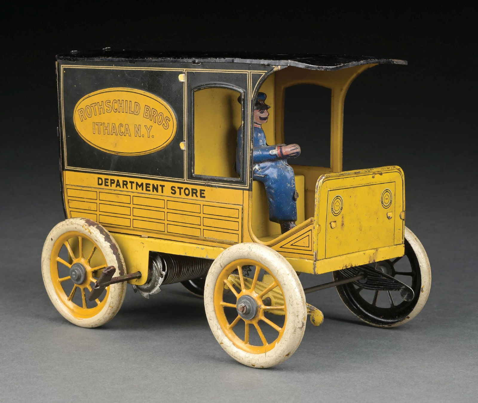 GERMAN TIN LITHO WIND-UP HANS EBERL ROTHSCHILD BROS., NEW YORK DEPARTMENT STORE TRUCK: CONDITION: Original driver, original back doors. Does not have steering wheel and column. Slight crease on top of roof and some minor wear throughout, especially on wheels. Very good to excellent cond