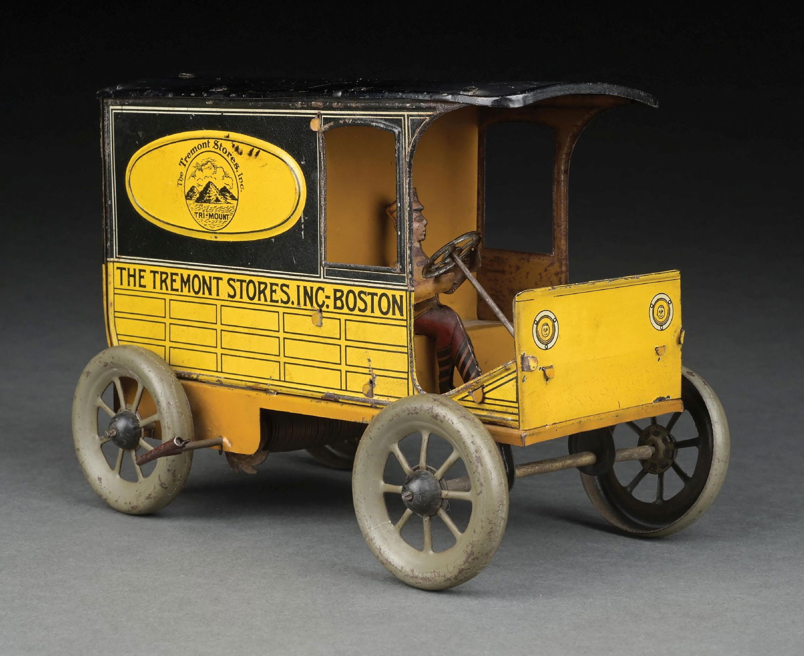 GERMAN TIN LITHO HANS EBERL TREMONT STORES TRUCK: A tin litho wind-up truck with the original driver and back doors. Marked "Germany" on the bottom of the rear door. There is some minor scratching and wear to the roof and throughout the truck. CONDIT