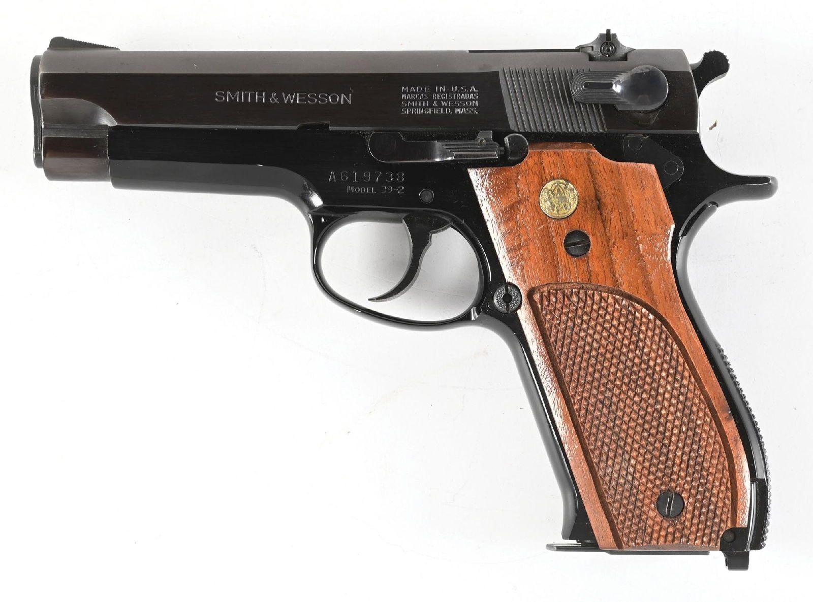 (M) SMITH & WESSON MODEL 39-2 SEMI-AUTOMATIC PISTOL.: Blued finish, ramped front sights, adjustable square notch rear, and 2-piece checkered walnut grips with gold washed Smith & Wesson medallions. With four additional magazines. CONDITION: Very good, li