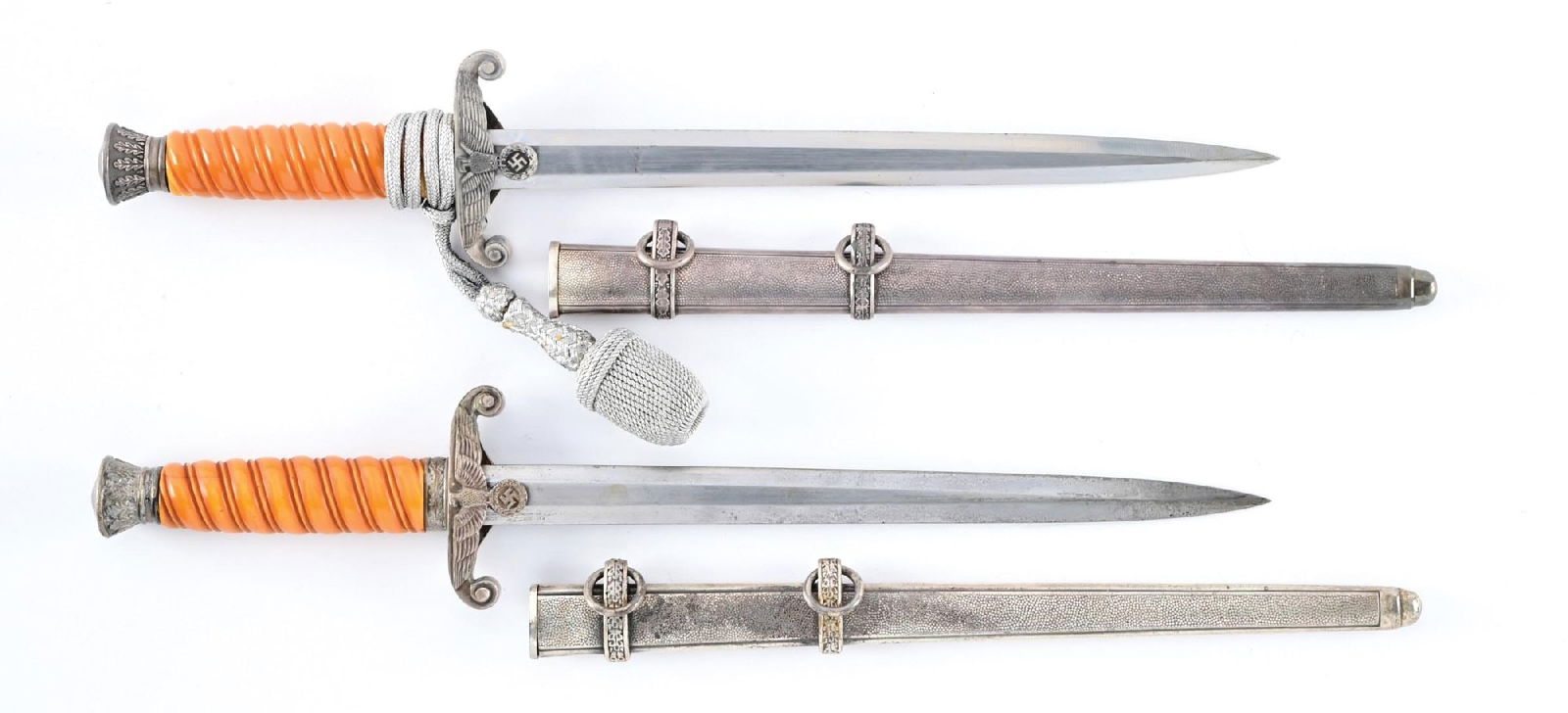 LOT OF 2: GERMAN WWII HEER DAGGERS.: Lot consists of: (A) Heer dagger with a "PUMA / SOLINGEN" marked blade that exhibits visible cross graining, moderate runner marks, and scattered blemishes. Plated fittings exhibit patina and oxidatio