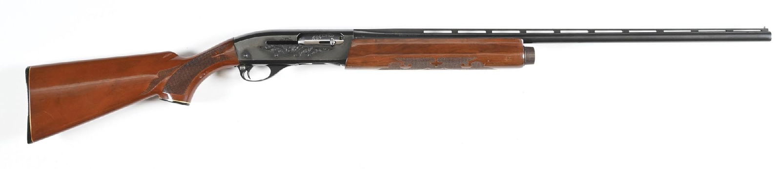 (M) REMINGTON MODEL 1100 SEMI-AUTOMATIC 12 GA SHOTGUN.: Classic circa 1970s production with blued finish, ventilated rib barrel, double bead sights, machine engraved receiver, and fleur-de-lis pattern press checkered stocks. CONDITION: Very Good. Bright bo
