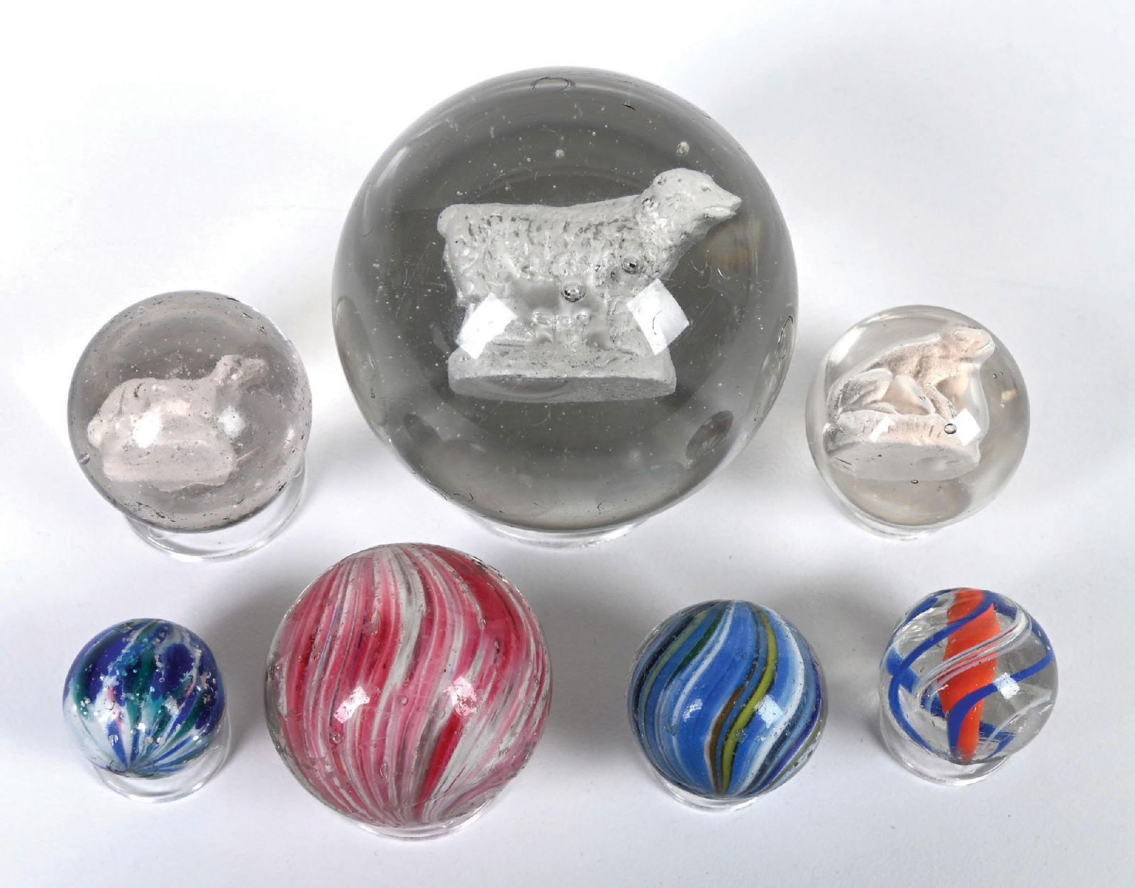 LOT OF 7 HANDMADE MARBLES: This is a nice lot of seven handmade marbles. Standing bear sulphide is 2-1/4". The mall dog and frog sulphide are 1-1/4". The pink onion is 1-1/4". The small blue onion with mica is 7/8". The blue on
