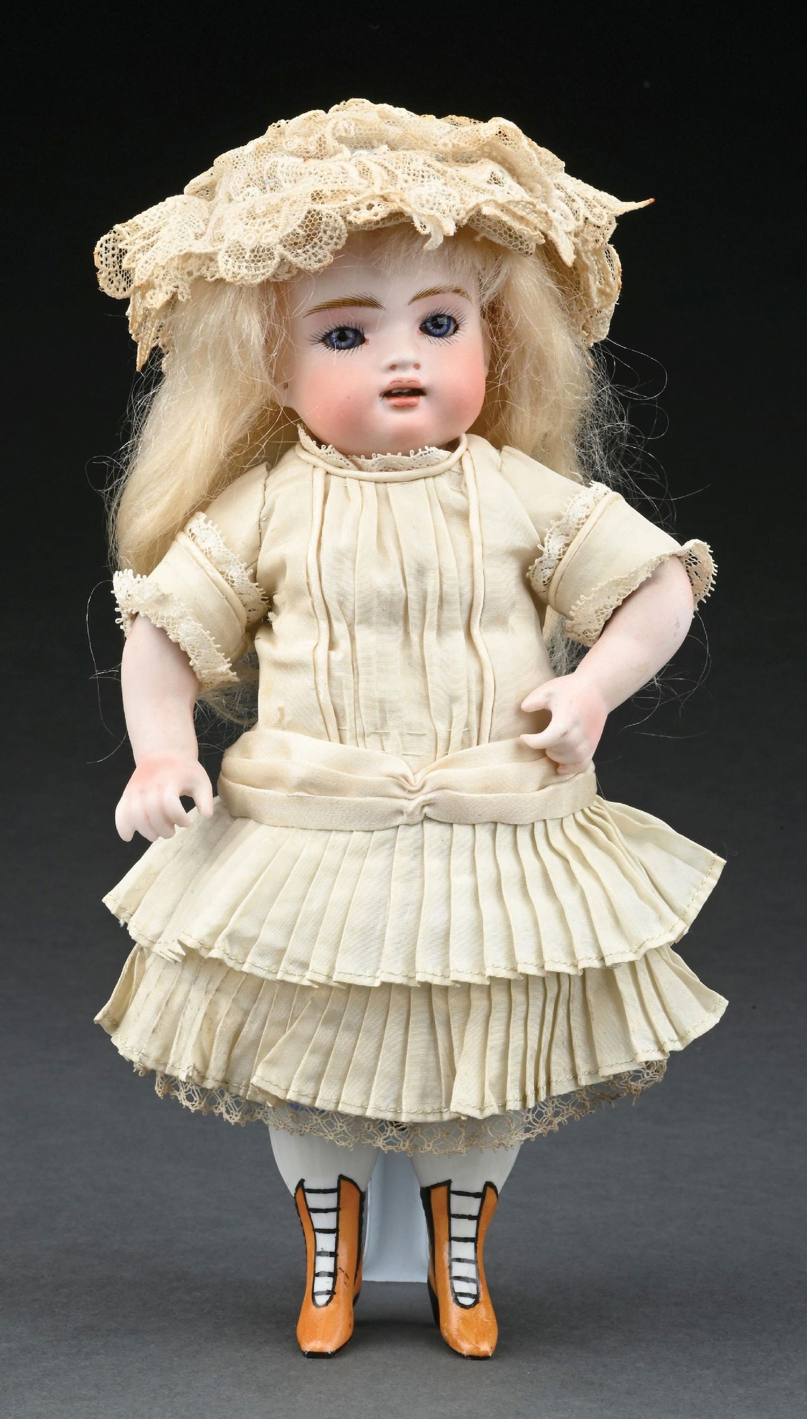 EXCEPTIONALLY PRETTY GERMAN ALL BISQUE DOLL W/ GLASS EYES, OPEN MOUTH, INCISED "102", KNOWN AS THE: This lovely child has blue glass eyes that still sleep, an open mouth with tiny little upper teeth, all Bisque chunky body, yellow boots with black heels that are an integral part of the lower Bisque