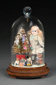 SMALL BISQUE DOLL ENCLOSED IN GLASS NEXT TO SMALL CHRISTMAS TREE: Figures and presents around tree. Doll looks like it has original clothing and displays well. Condition: (Very Good - Excellent). Dimensions: 6" T.