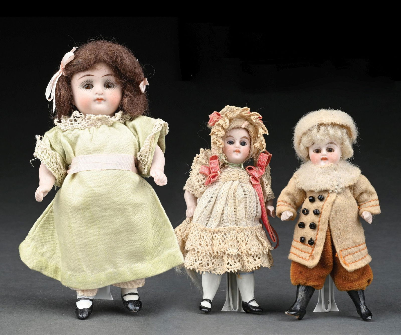 LOT OF 3: VERY NICE SMALL ALL BISQUE DOLLS: (A) The two smaller ones, which are identical in nature other than one is dressed as a boy and the other a girl. Both with open heads with permanently fixed tiny glass bead eyes, closed mouths, one-pi