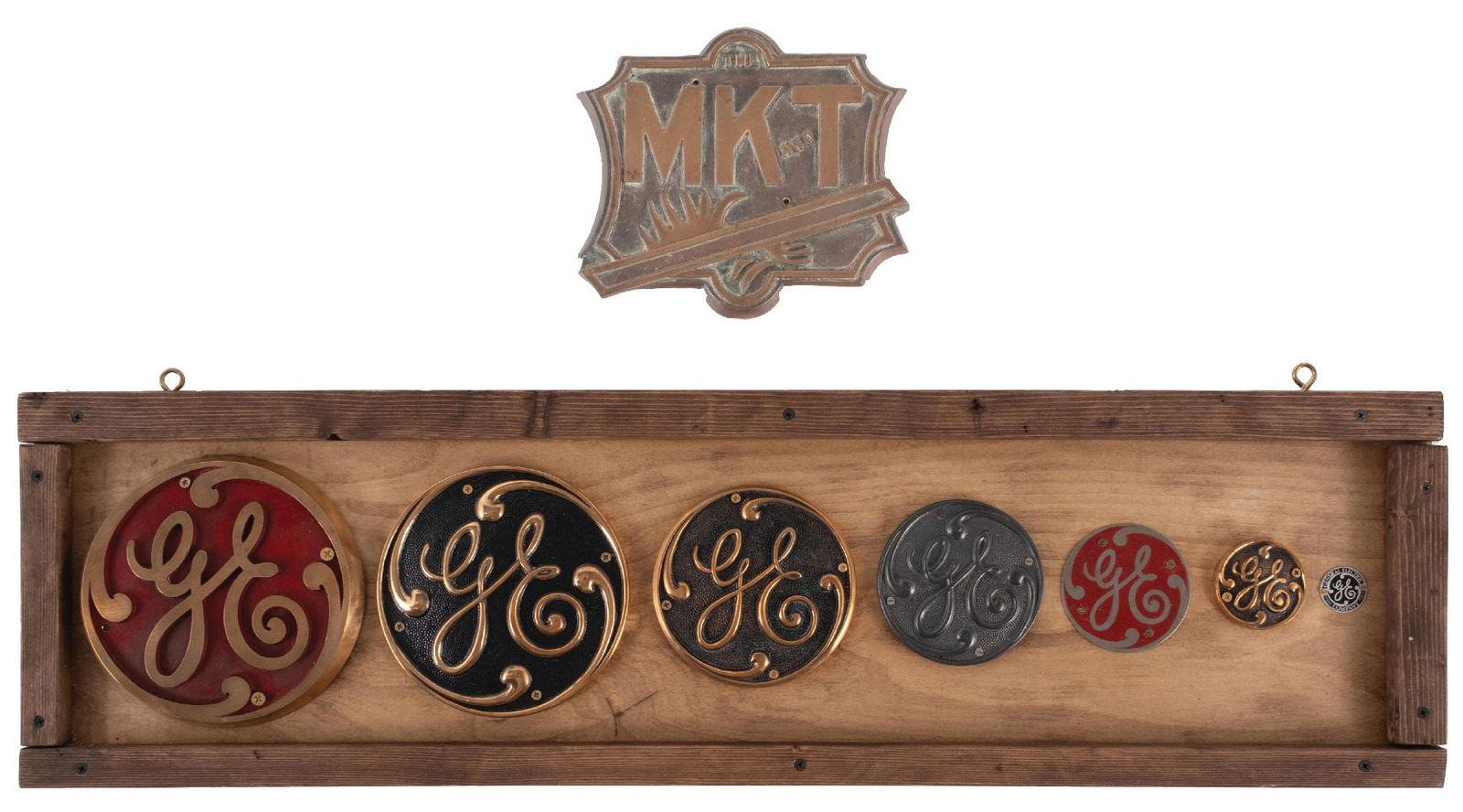 PAIR OF GENERAL ELECTRIC & THE MK AND T ADVERTISING SIGNS: CONDITION: (A) A display board showing seven different General Electric cast logos off of potentially buildings or machinery. Some are brass, some are tin, and one is plastic. No breaks or repairs. Mo