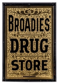 GOLD LEAF-FILLED CHIPPED GLASS SIGN ADVERTISING BROADIE'S DRUG STORE