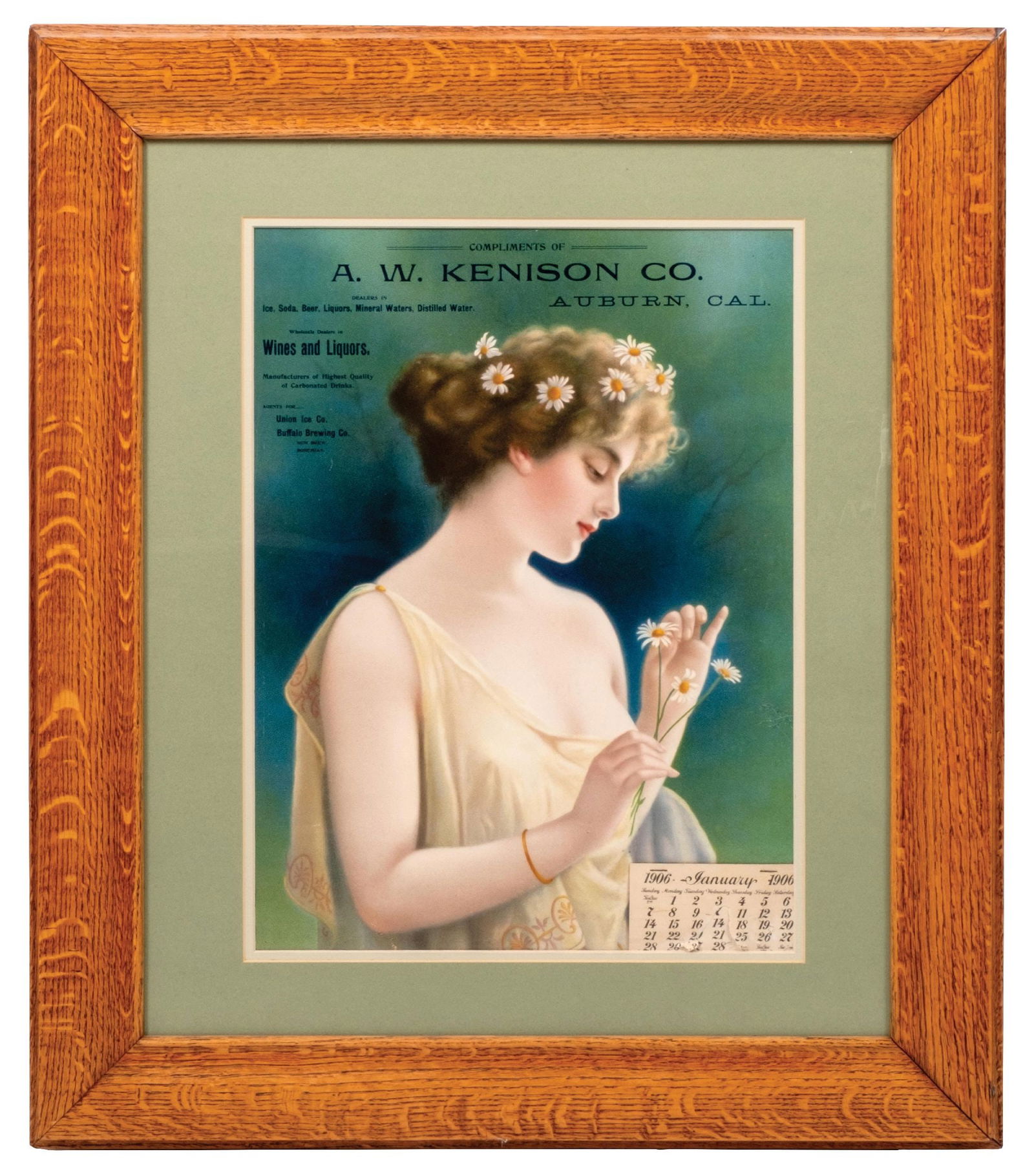A.W. KENISON CO. CALENDAR IN FRAME OF BEAUTIFUL WOMAN WITH DAISIES IN HAIR: Housed in a beautifully restored quartersawn oak period frame, a peper lithograph with a 1906 calendar pad. Reads "Compliments of A.W. Kenison Co., Auburn, California, Wines & Liquors, Also Agents for