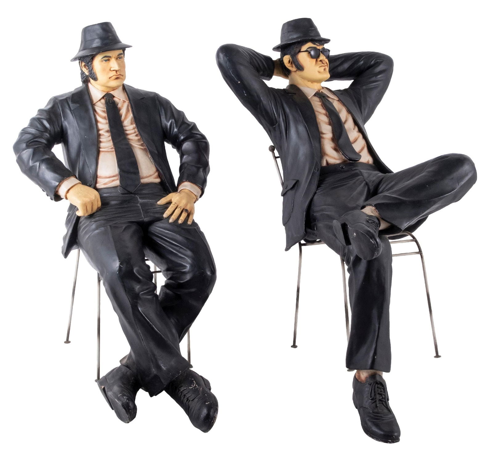 PAIR OF BLUES BROTHERS FIGURES IN CHAIRS: Pair of contemporary fiberglass statues of the Blues Brothers: Jake and Elwood, in the sitting position on chairs. CONDITION: Showing little wear, with no breaks, cracks or repairs. Great color and li