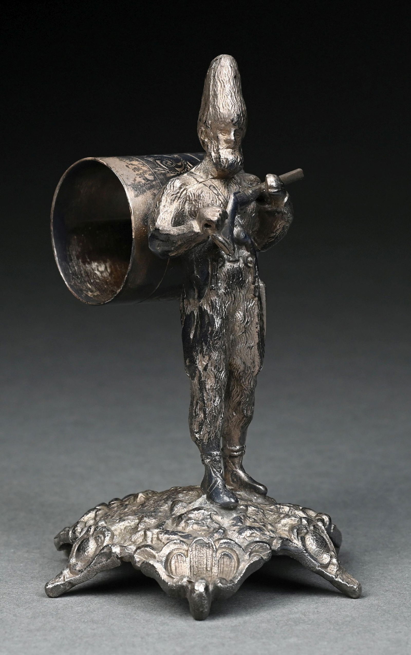 LARGE FIGURAL NAPKIN RING: A large mountain man wearing a tall hat, carrying a rifle, pistol and knife sheath on belt; napkin holder on back, standing on base. Mark on base looks like a flag with letters that appear to be N & B