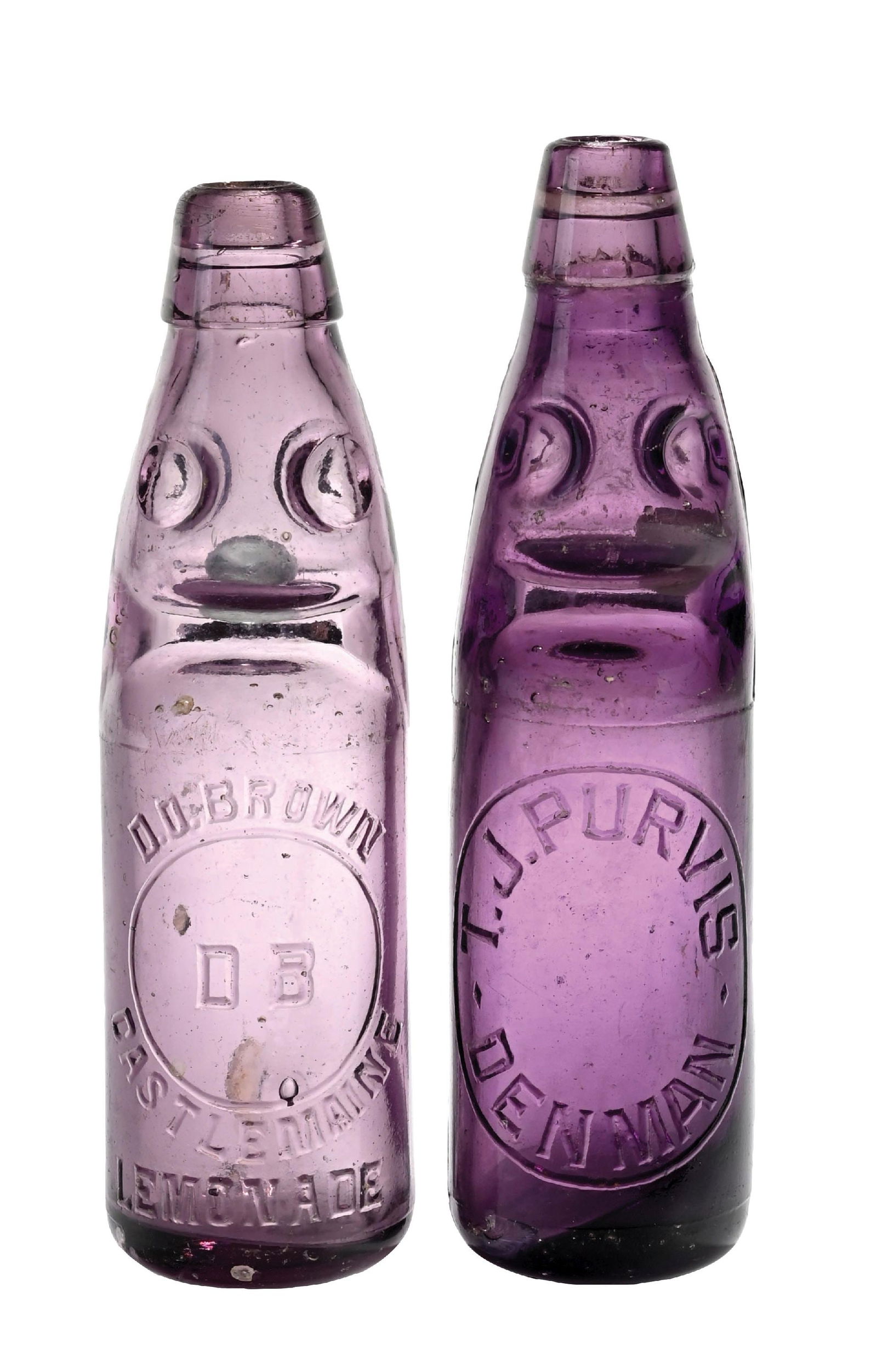 LOT OF 2: VINTAGE PURPLE GLASS CODD-NECK SODA BOTTLES: (A) Amethyst glass Codd-neck bottle, embossed "D.O. BROWN CASTLEMAINE LEMONADE". Bottle has blown bubbles throughout and some light fleabites. (7.5). (B) Amethyst Codd-neck bottle, embossed "T.J. PURV
