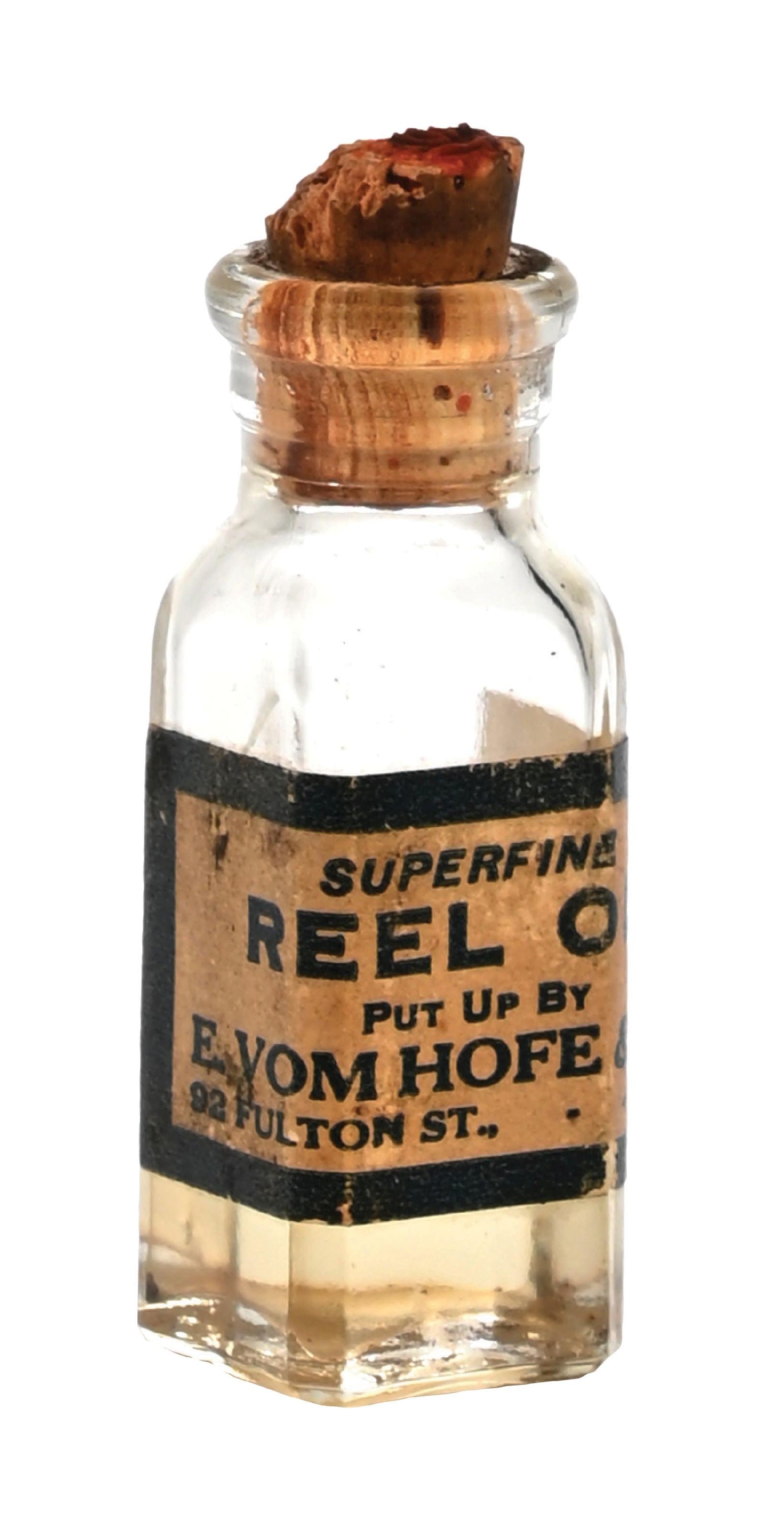EDWARD VOM HOFF & CO. SUPER FINE REEL OIL: This bottle has an almost completely intact original label, original cork, and contains what is potentially the original reel oil. There is pencil writing on the original paper label. There is some il