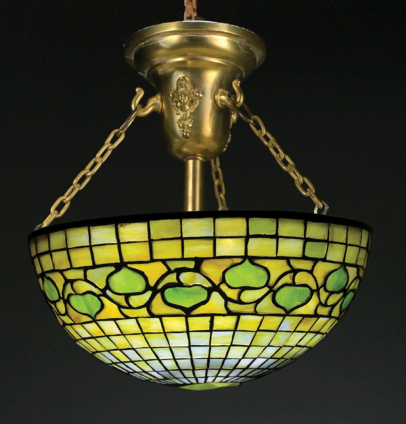 TIFFANY STUDIOS ACORN TURTLEBACK LEADED GLASS HANGING LAMP: A beautiful example of a turtleback acorn leaded glass hanger by Tiffany Studios. The 12" diameter shade features the leaf and vine (acorn) motif with central turtleback tile. The shade has a backgrou