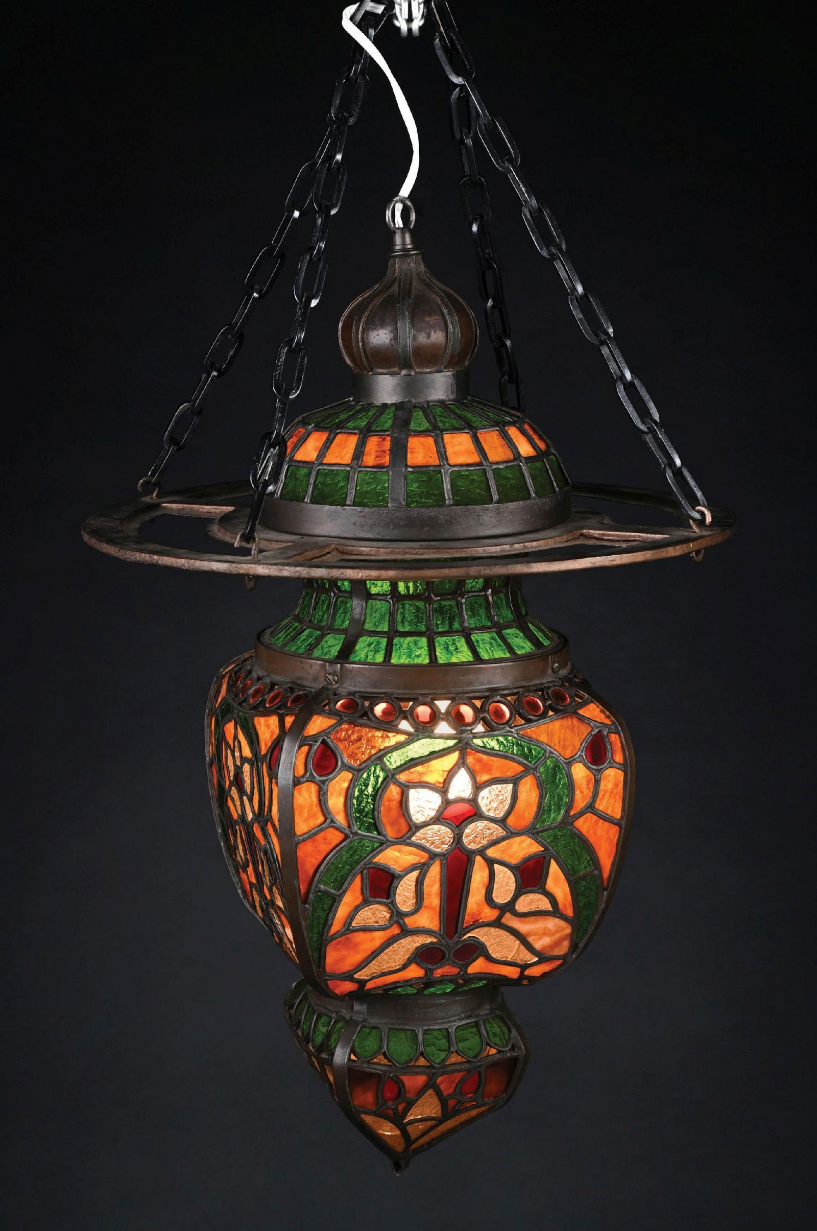 STAINED GLASS APOTHECARY HANGING LAMP: A gorgeous stained glass apothecary-style hanging fixture. The elaborate fixture is composes of beautiful granite-back leaded glass in shades of greens, reds, oranges, and whites. The two piece fixtur
