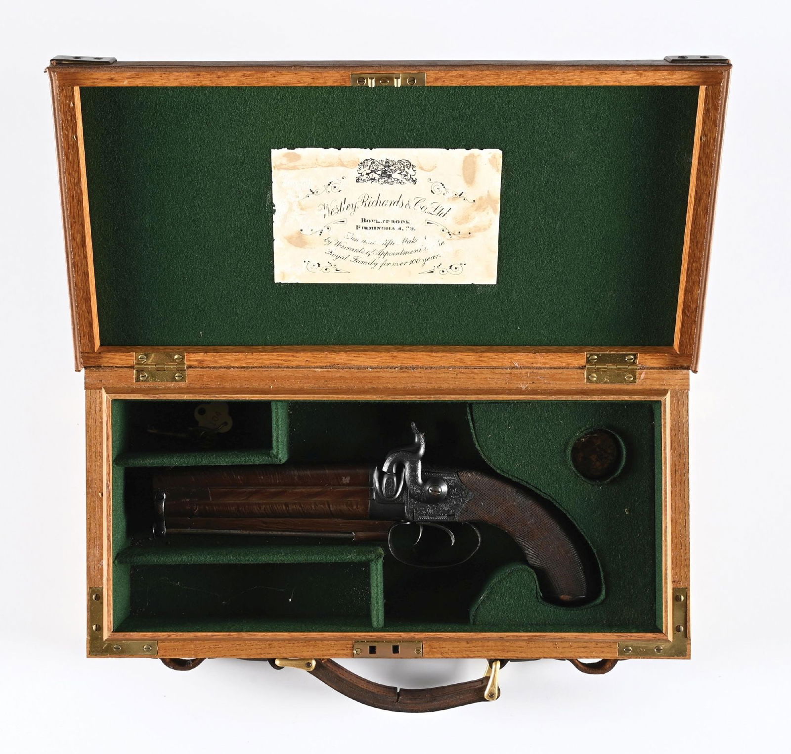 (A) CASED WESTLEY RICHARDS MARKED PERCUSSION HOWDAH PISTOL.: This percussion over under large bore pistol features an engraved frame, dual triggers and dual exposed hammers, brown Damascus barrels with checkered walnut grip and engraved trap door metal butt. CO