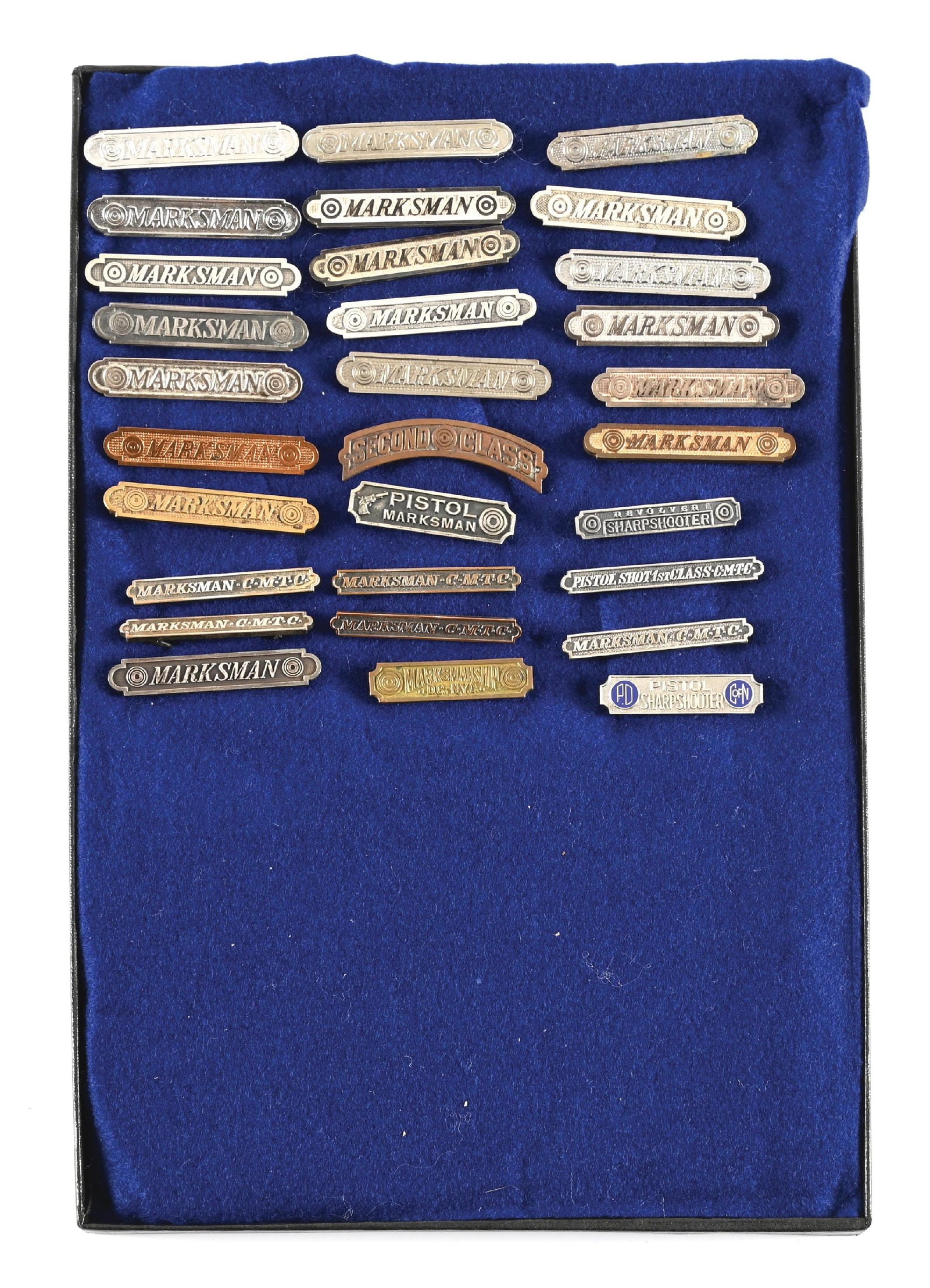 RIKER MOUNT OF 30 MARKSMANSHIP BADGES.: Lot contains 30 pre-World War II-post World War II era marksmanship badges all nicely displayed in a riker mount. All badges exhibit varying degrees of patina with light blemishes. CONDITION: Good-ver