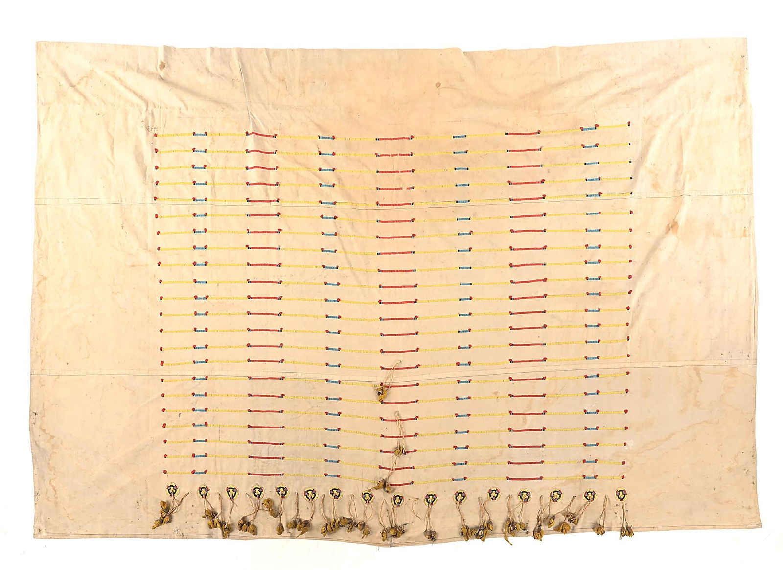 CHEYENNE (SUHTAI/TSITSISTAS) TIPI LINER: Turn of the 19th century. Features 16 sinew sewn 2-1/2" beaded rosettes of white heart red, greasy yellow, black and blue beads. The rosettes have buckskin fringe drops with dew claws and quilled loop