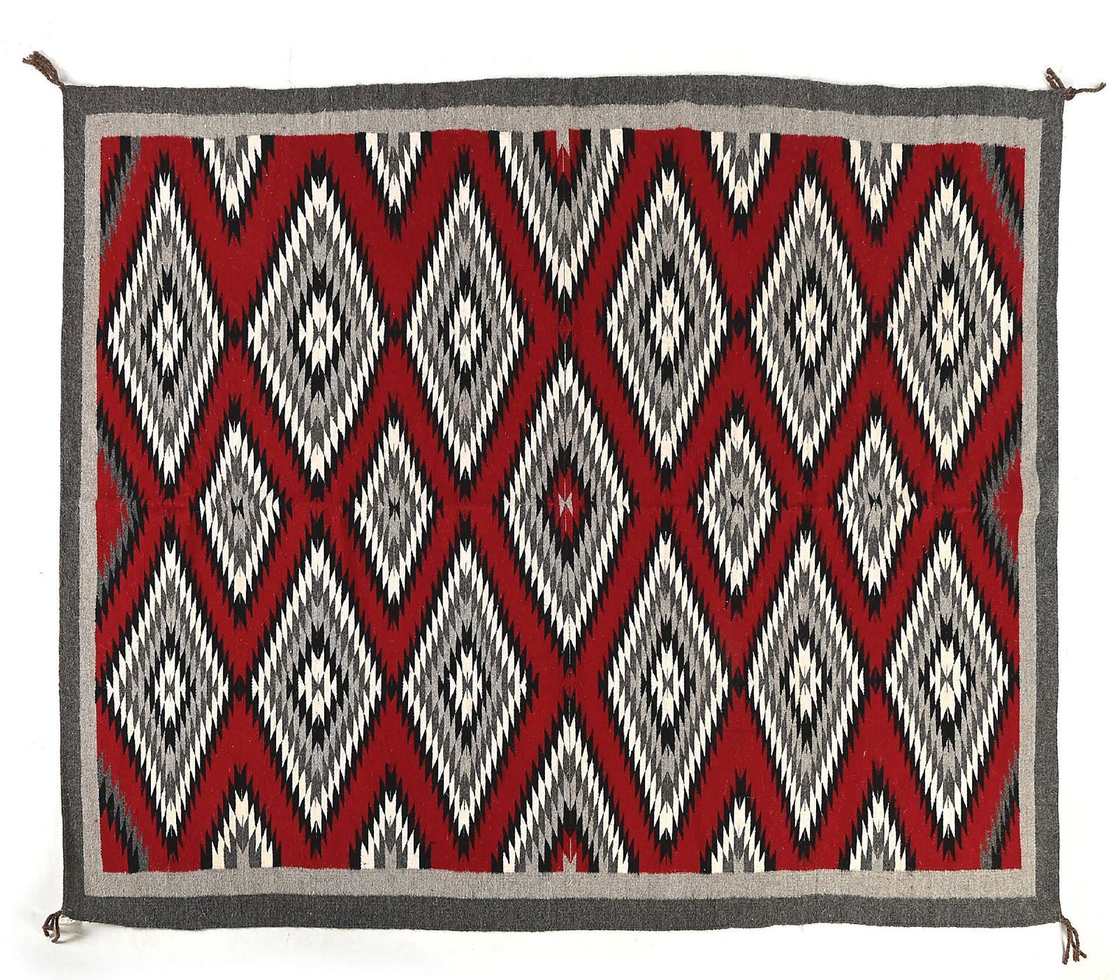 NAVAJO (DINÉ) RUG: Contemporary. With three vertical rows of centralized serrated diamonds. Attached tag "Weaver: Clara John Bez / Area: Pinion Hill". Dimensions: 64" x 82-1/2" Colors: Red, Light Grey, Dark Grey, Black