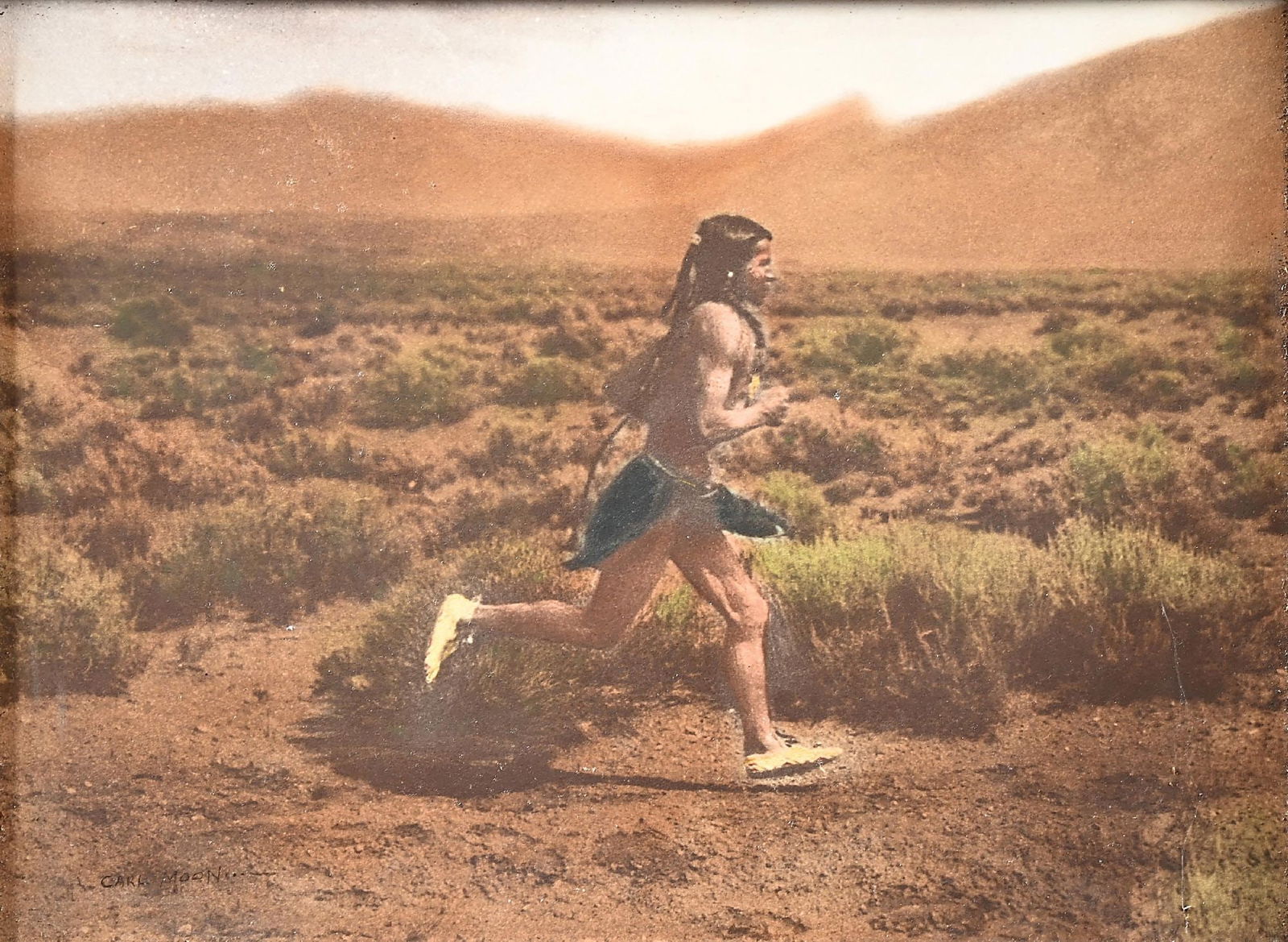 CARL MOON (AMERICAN, 1878-1948): The Runner Taos, New Mexico. View #1 Running right color tinted photograph signed "Carl Moon" lower-left corner sight: 12" x 16" framed: 24-3/4" x 20-1/2" in original ornate gold tone wood frame with