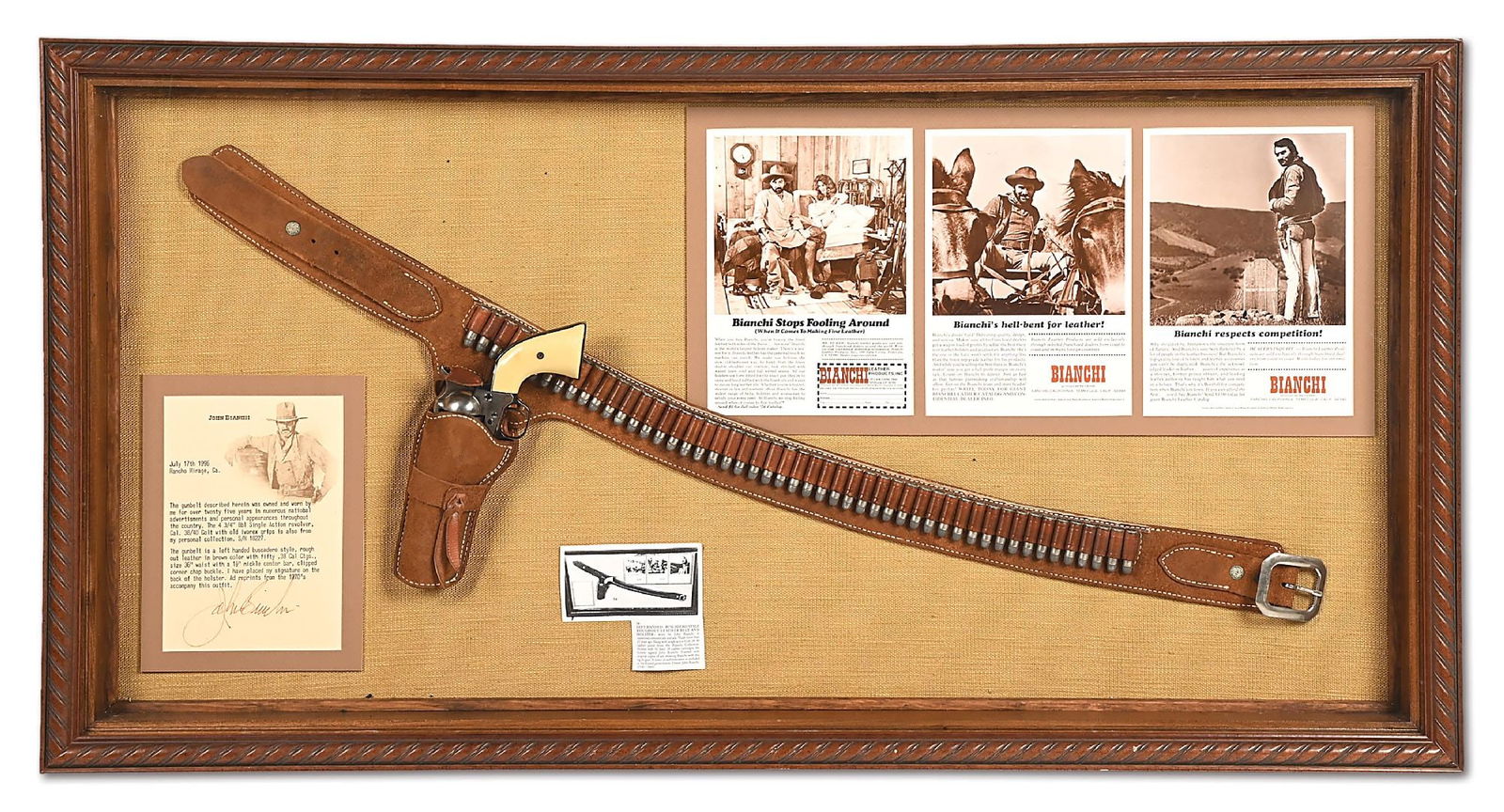 (A) FRAMED COLT SAA REVOLVER AND PROMOTIONAL BIANCHI BUSCADERO BELT RIG FROM THE COLLECTION OF JOHN: As donated by John Bianchi for an unknown circa 1996 auction, this attractive shadow box framed display features a left handed brown rough side out leather buscadero rig by Bianchi in print ads and co