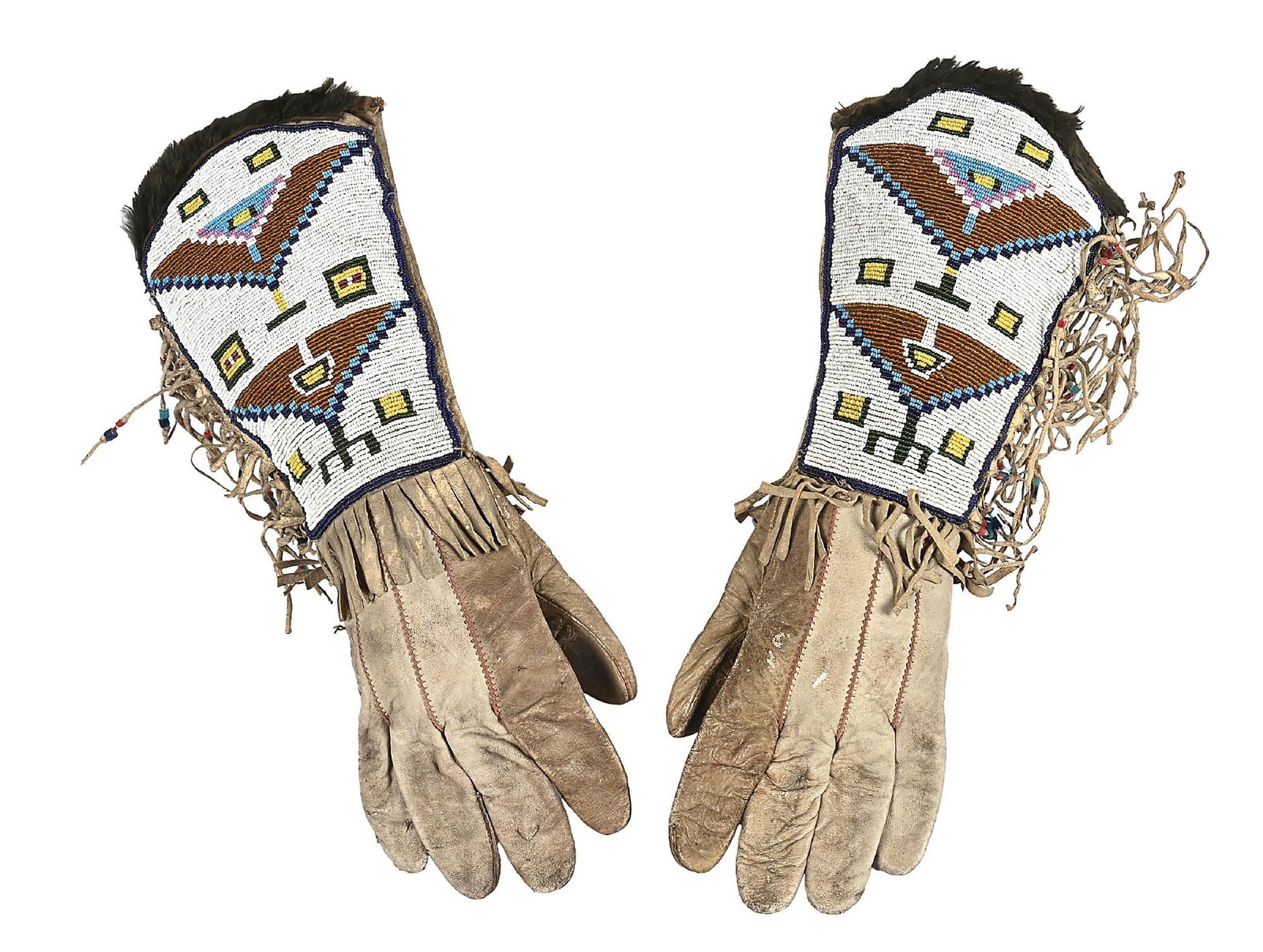 PLATEAU BEADED GAUNTLETS: Circa turn of the 19th century. With a fully-beaded elongated cuff and fringe with large tube beads attached, finished with a fur ruff. Condition: Fringe and portion of gauntlet stiff. Bead Colors: Wh