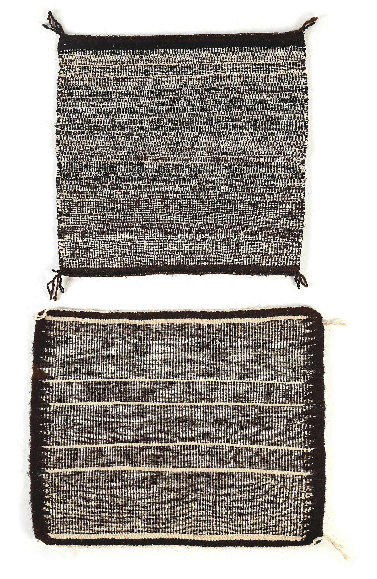 LOT OF 2: NAVAJO (DINÉ) RAISED OUTLINE SINGLE SADDLES: Both mid-20th century. Colors: Dark Brown, White Condition: Curled corners. Dimensions: (A) 27" x 32". (B) 26 - 1/2" x 28 - 1/2". Dimensions: Largest: 27" x 32".