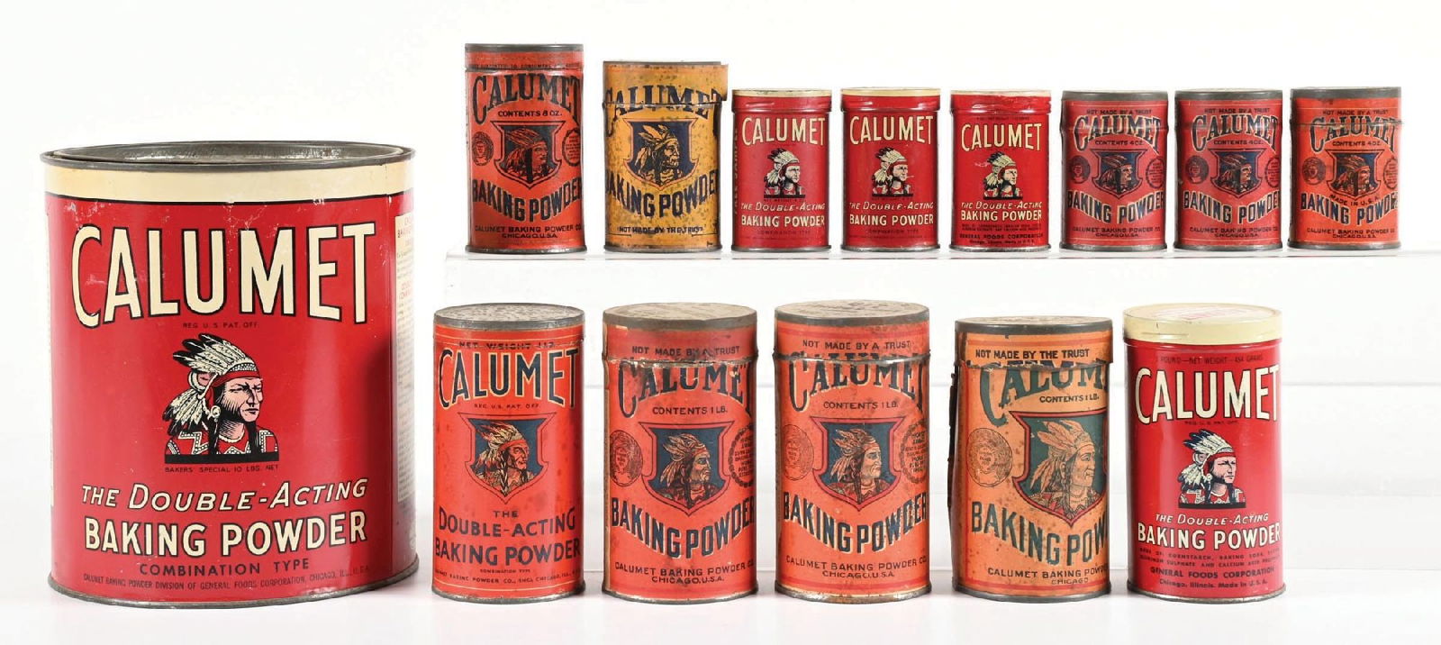 COLLECTION OF 14: CALUMET BAKING POWDER TINS & PACKAGES: CONDITION: Consists of large, small, and medium-size format packaging of Calumet Baking Powder. Most with the iconic Native American graphic. Shows some areas of scuffs, scrapes, and areas of lifting