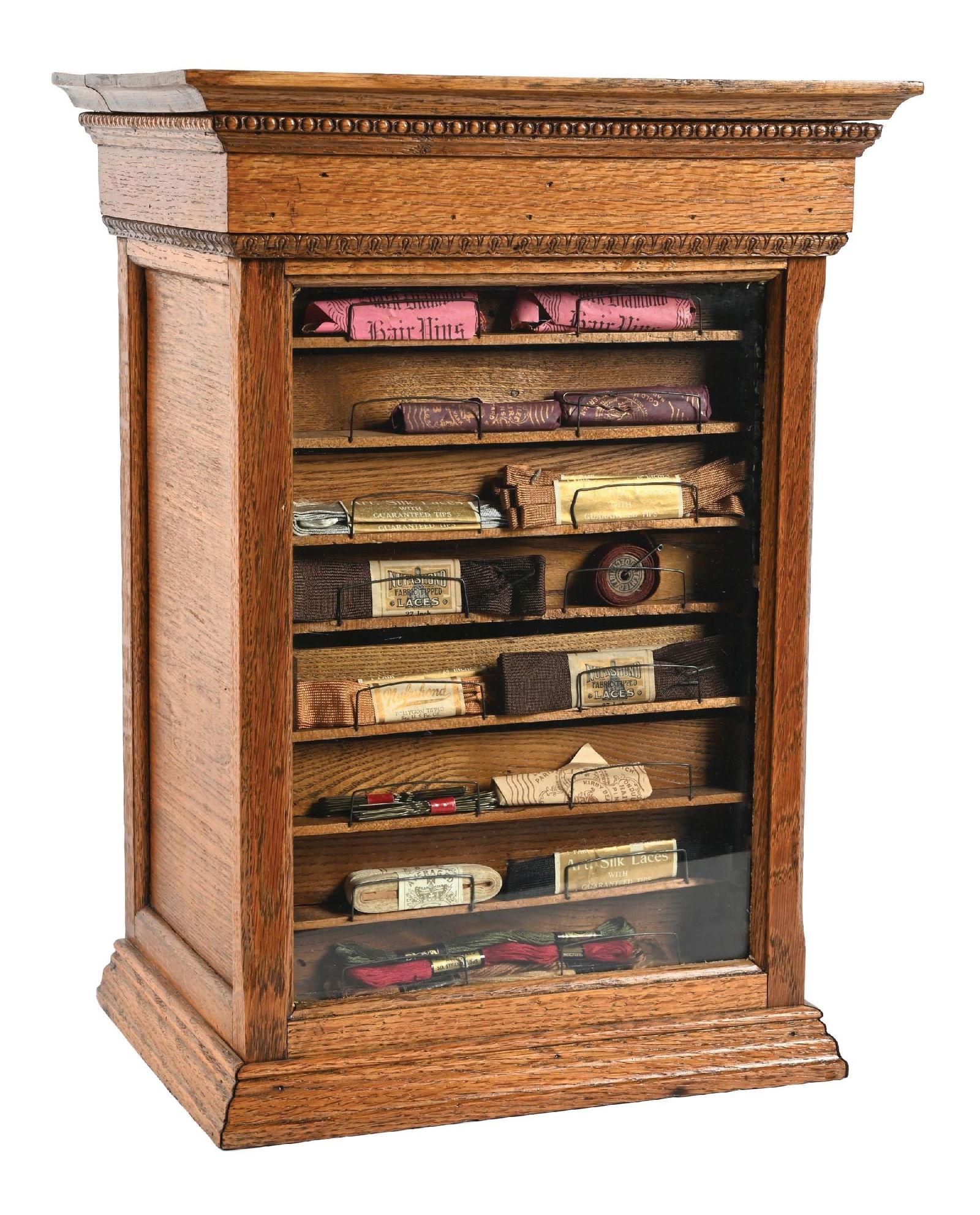 COUNTRY STORE COUNTERTOP SHOELACE DISPLAY: CONDITION: Oak construction, with some decorative beadwork. It has an original glass front, and display area with a small assortment of laces and material. Eight original back drawers, showing origina