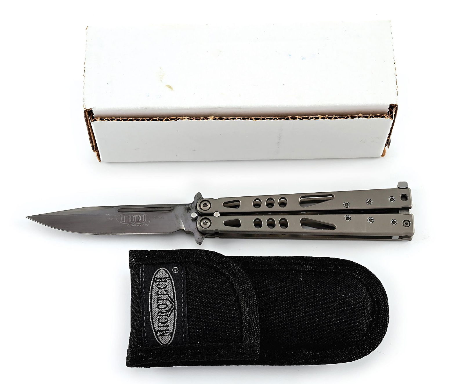 BOXED MICROTECH TACHYON.: Tachyon balisong by Microtech that features a black 14-4 CrMo clip point blade with fullers. Blade is marked "TACHYON" with Microtech logo. Numbered "0331" and dated "12/2001". Skeletonized bead
