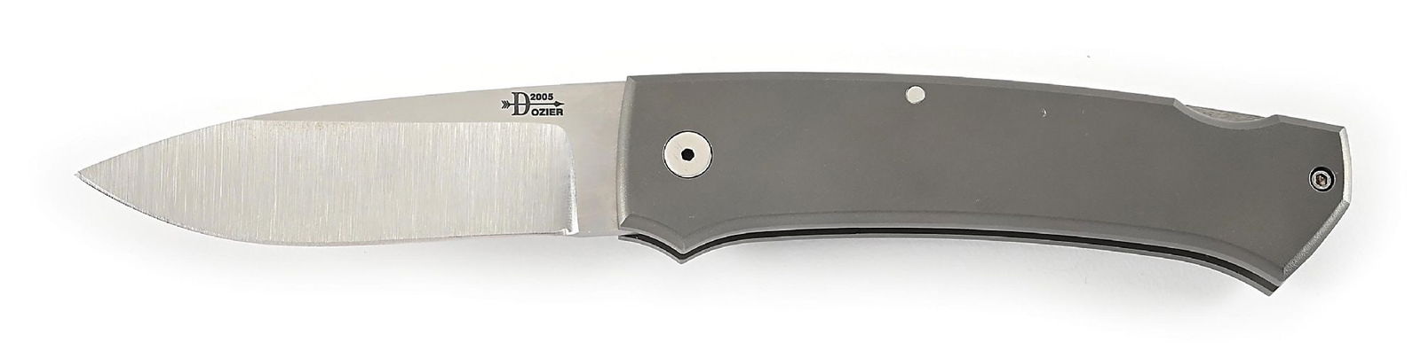 BOB DOZIER CUSTOM TITANIUM LOCK BACK HUNTER.: Appears unused and unsharpened. 154-CM steel blade with thumb stud opener. “Dozier 2005” etched on obverse blade. Locks open firmly. Titanium frame. Pocket clip. Closed length 4 - 7/8̶