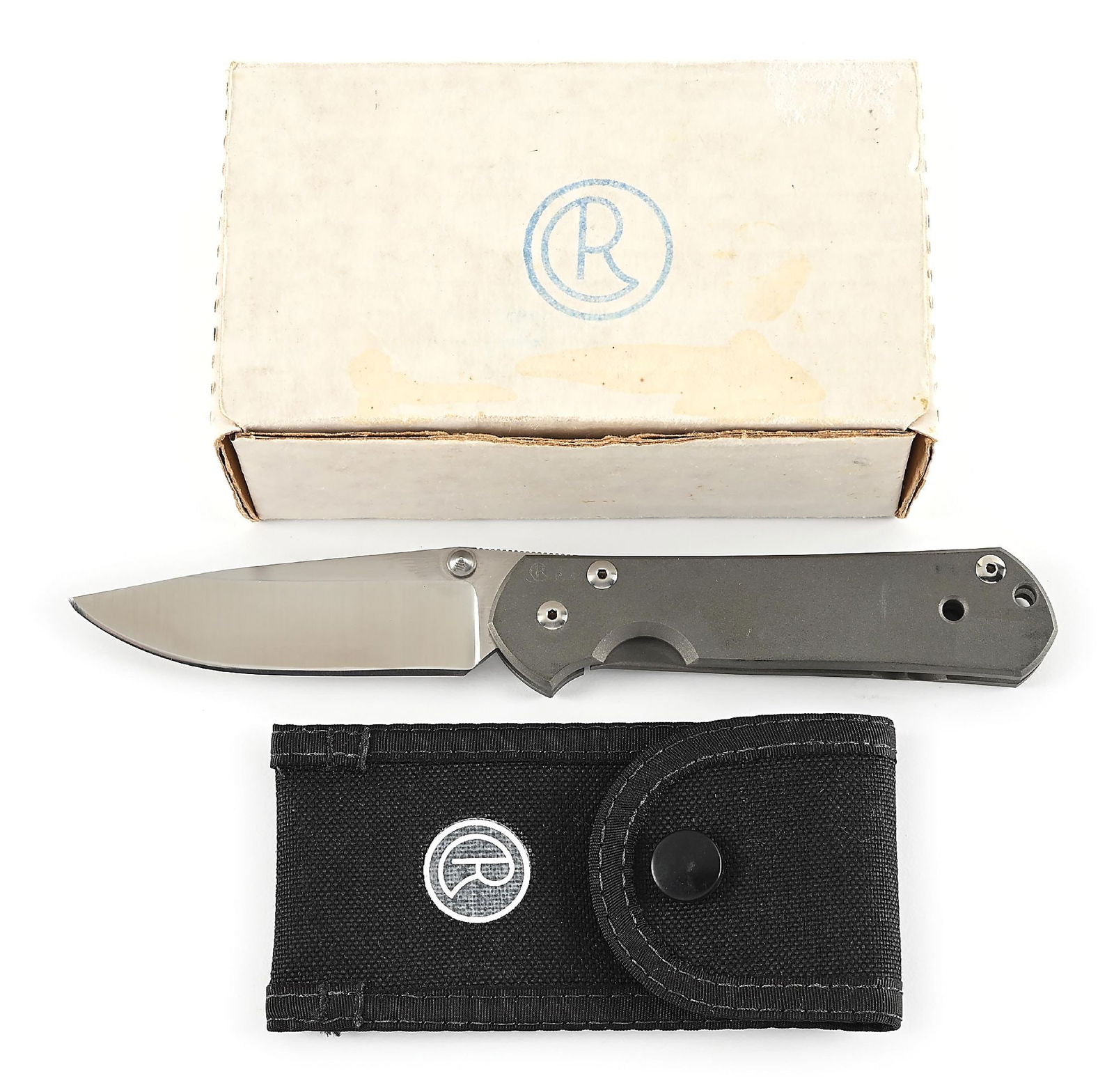 BOXED CHRIS REEVE LARGE SEBENZA "P" FOLDING KNIFE.: Features a satin finished ATS-34 blade with thumb stud and knurled thumb rest. Titanium frame is marked near the pivot screw on obverse with the “CR” logo and "P245". The knife operates us