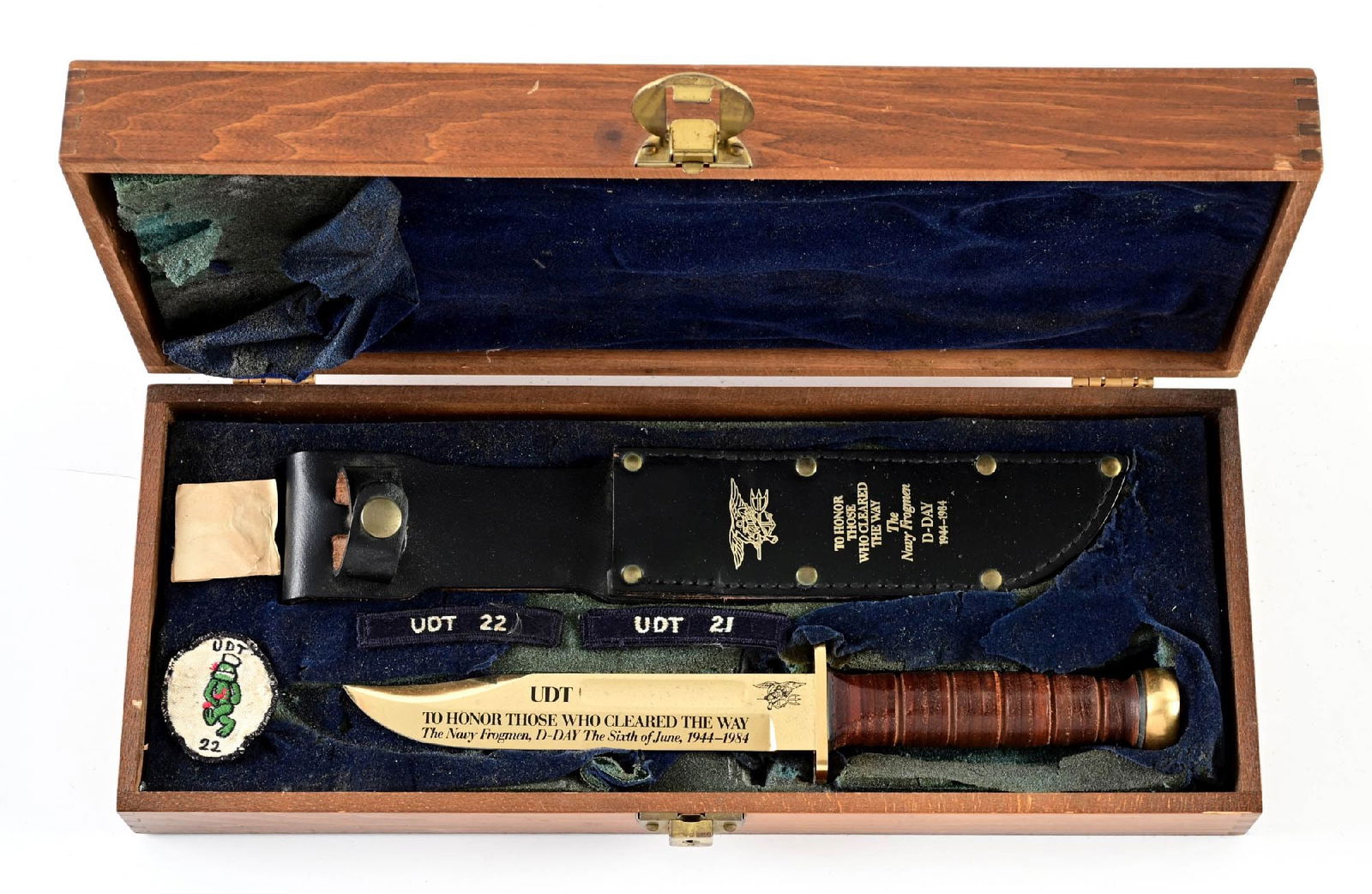 CASED UDT D-DAY WENOKA COMMEMORATIVE KA-BAR KNIFE.: Made by Wenoka to commemorate the UDT and their part on D-Day, June 6th, 1944. Features a gold-plated stainless steel blade marked "WENOKA / 24K GOLD PLATED / STAINLESS STEEL / JAPAN" on the reverse r
