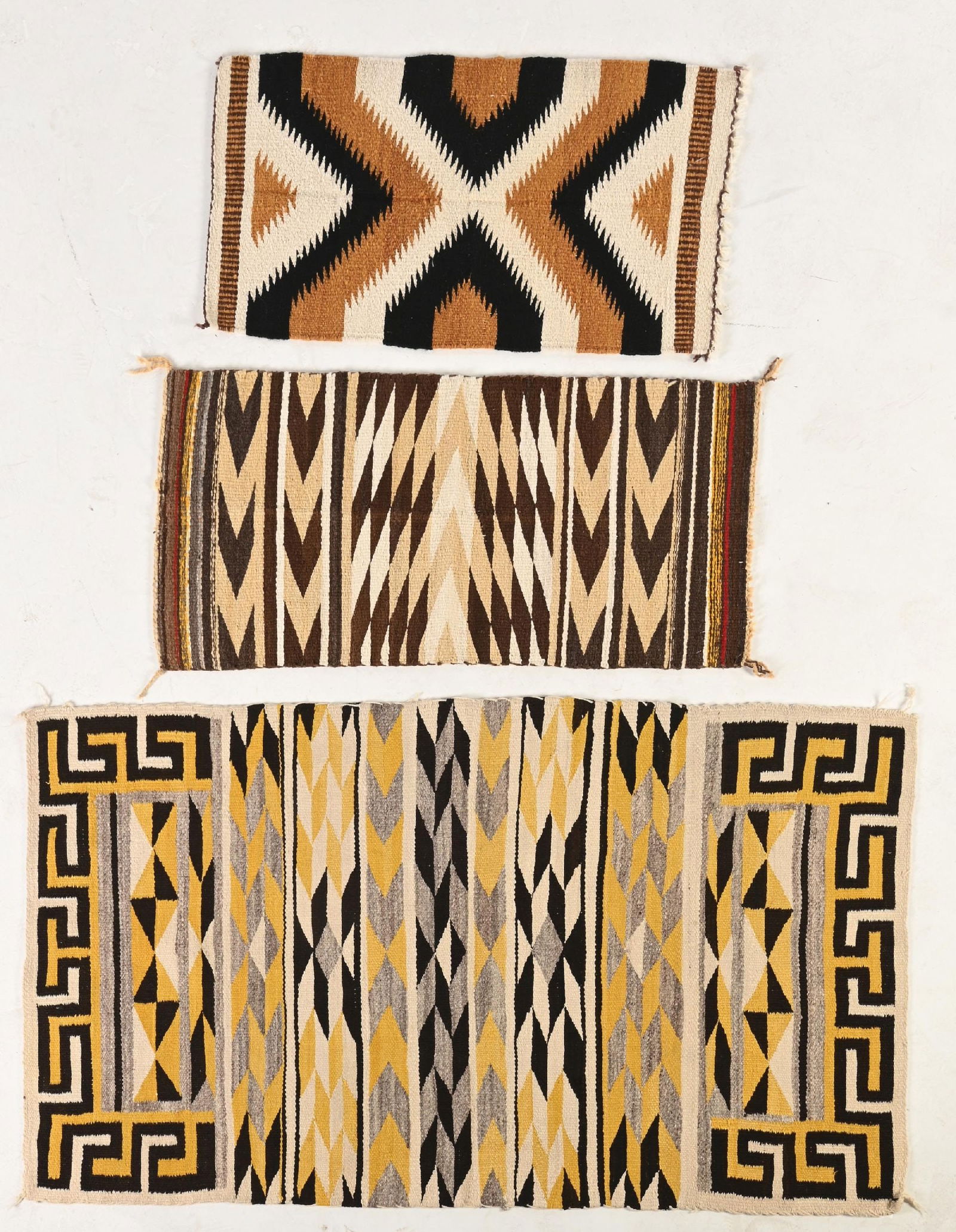 LOT OF 3: NAVAJO (DINÉ) RUGS: All contemporary. (A) Navajo Double Saddle blanket Teec Nos Pos. Slight staining and showing warp. 62" x 34-1/2". (B) Gallup Throw. Some holes and warp showing. 42" x 19-1/4" (C) Gallup Throw. Warp