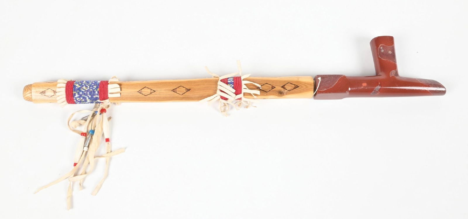 PIPE W/ STEM: Contemporary. Catlinite pipe with beaded wrapped stem. Dimensions: 3 - 3/4" x 25 - 1/2".