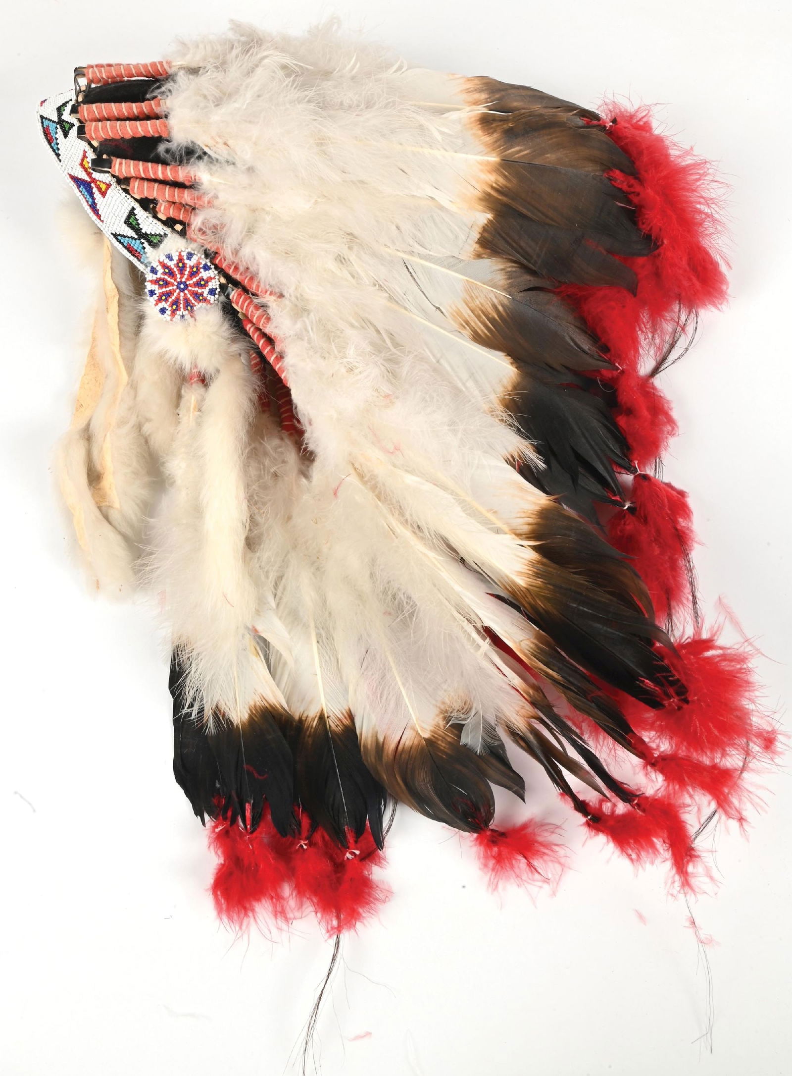 PLAINS HEADDRESS: Circa third quarter 20th century. Turkey feathers dyed to look like eagle feathers. Loom-beaded band and rosettes. Dimensions: 23" x 23".