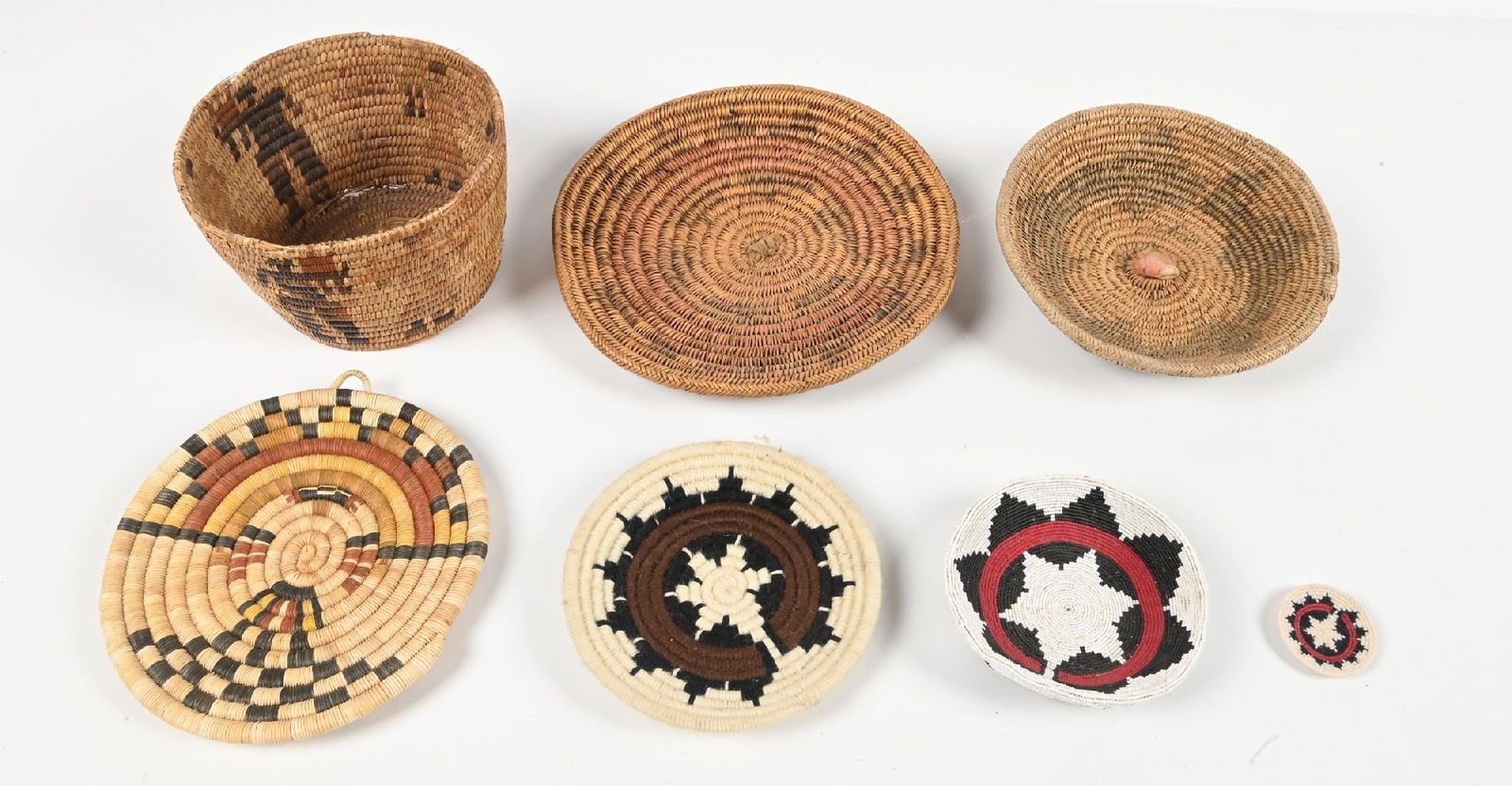 LOT OF 7: SOUTHWESTERN BASKETS: (A) Five Navajo Wedding Baskets, woven with Sumac, two woven with yarn, and one completely done with beadwork. (B) Hopi coiled basket of butterfly maiden Kachina. (C) Papago Basket in very poor