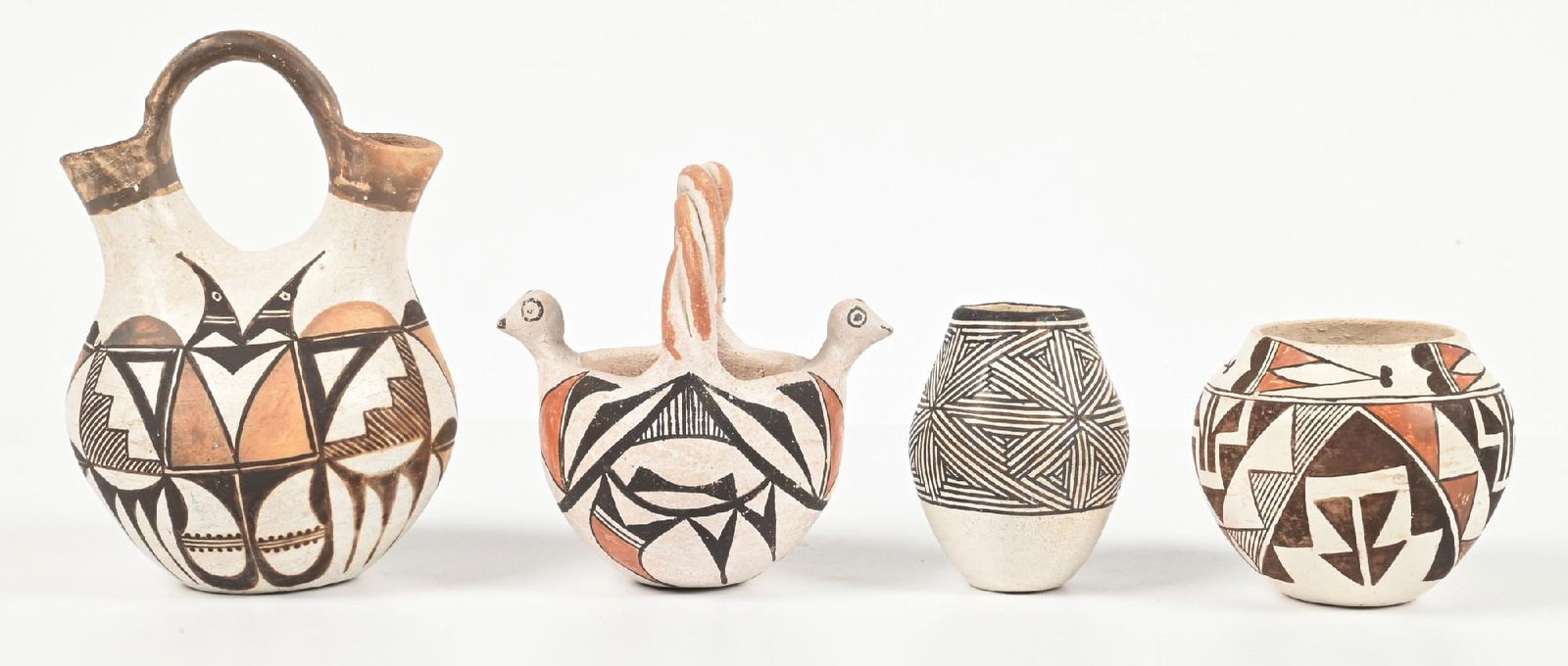 LOT OF 4: ACOMA (ÁAK’U) POTTERY ITEMS: (A) Miniature Wedding Vase. Some pot marks. (B) Handled bowl. (C) Signed "M Z Chino". (D) Miniature olla, signed "Acoma Sky City, N.M.". Rim chips. Provenance: Estate of N. Harman. Dimensions: