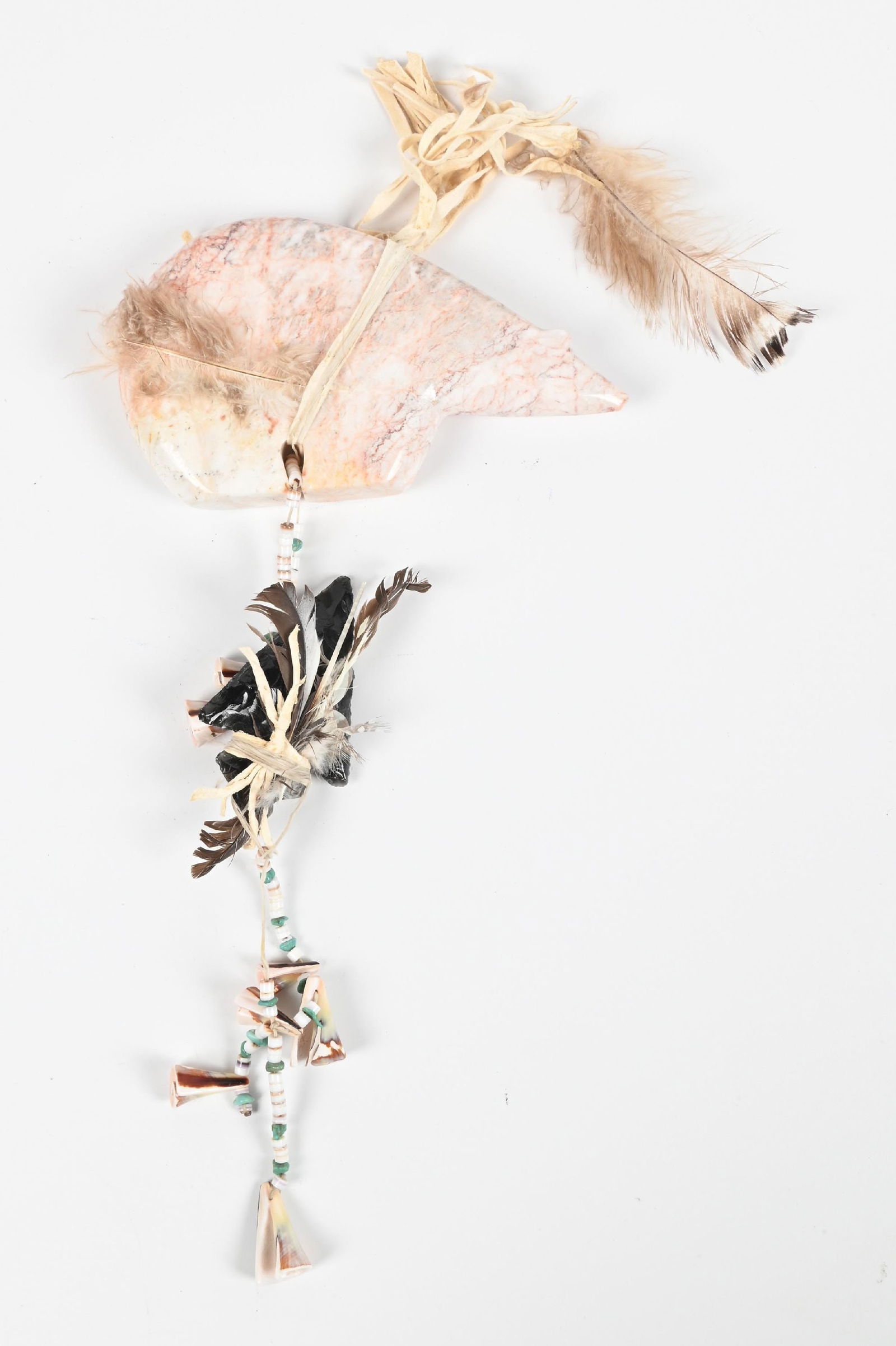 ZUNI FETISH OF A BEAR: Contemporary. Made with marble, adorned with heishei, turquoise, shell beads, obsidian arrowhead, and feathers. Dimensions: 6 - 1/2" x 4".