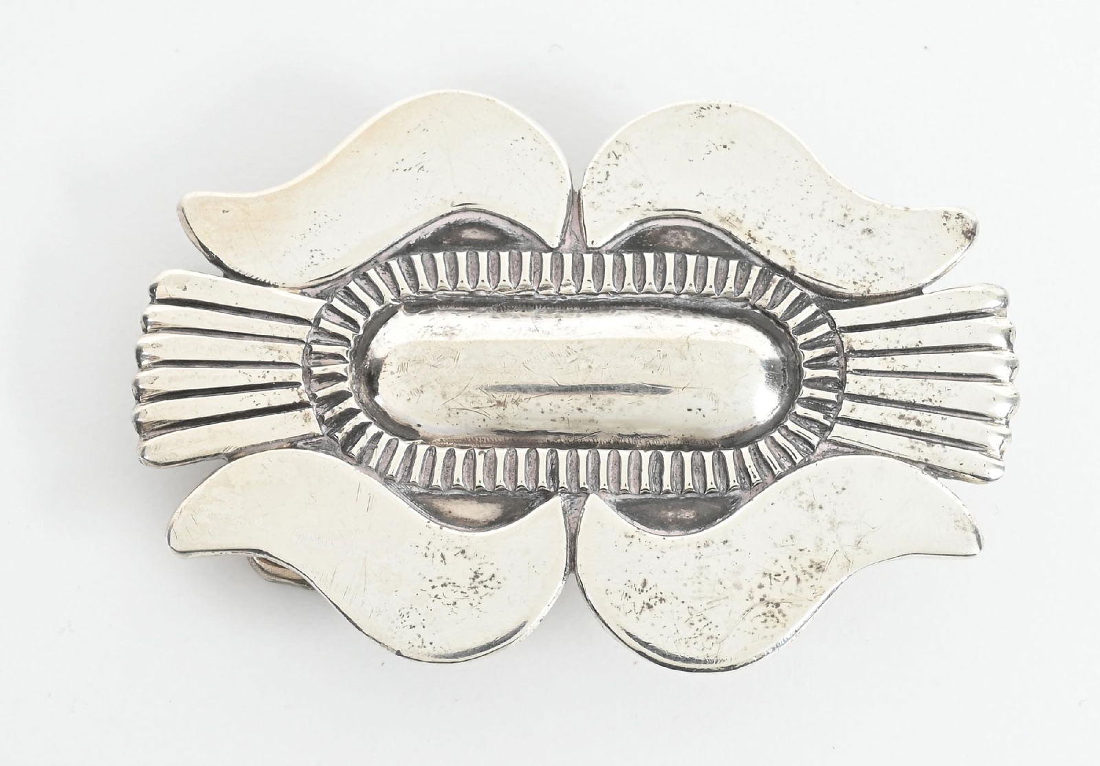 STERLING SILVER COCHITI BELT BUCKLE: Women’s ingot silver belt buckle by renowned Cochiti Pueblo artist Cipriano “Cippy” Crazyhorse. C. 1990s. Maker stamped to the reverse. Dimensions: 2 - 3/4" x 2".