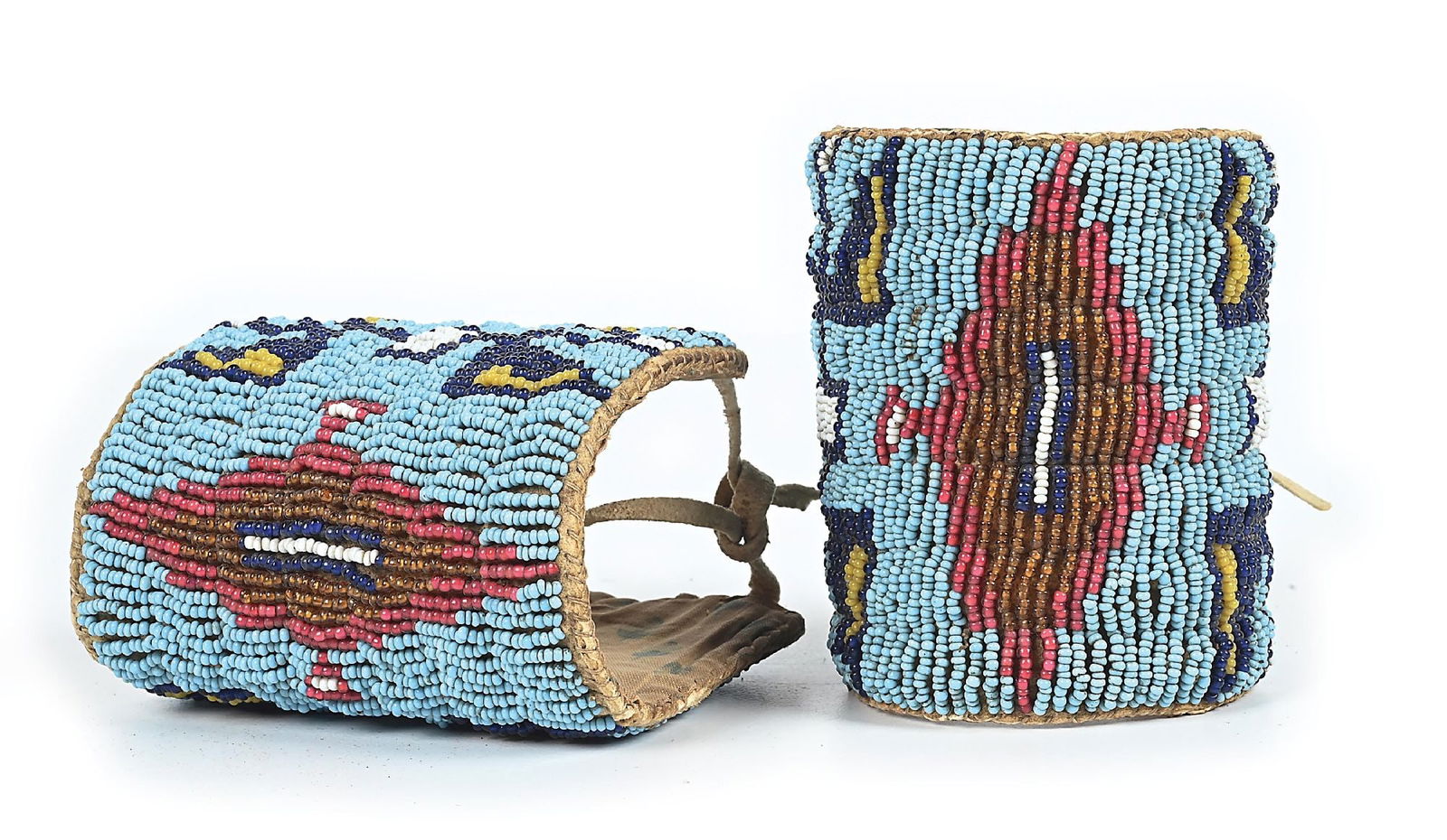 SIOUX (LAKOTA) CHILD'S CUFFS: Circa last quarter 19th century. Fully beaded with a central elongated diamond with a reflective geometric pattern on each side. Dimensions: 3-1/2" wide by 6-1/2" long Colors: Light Blue, Dark Blue,