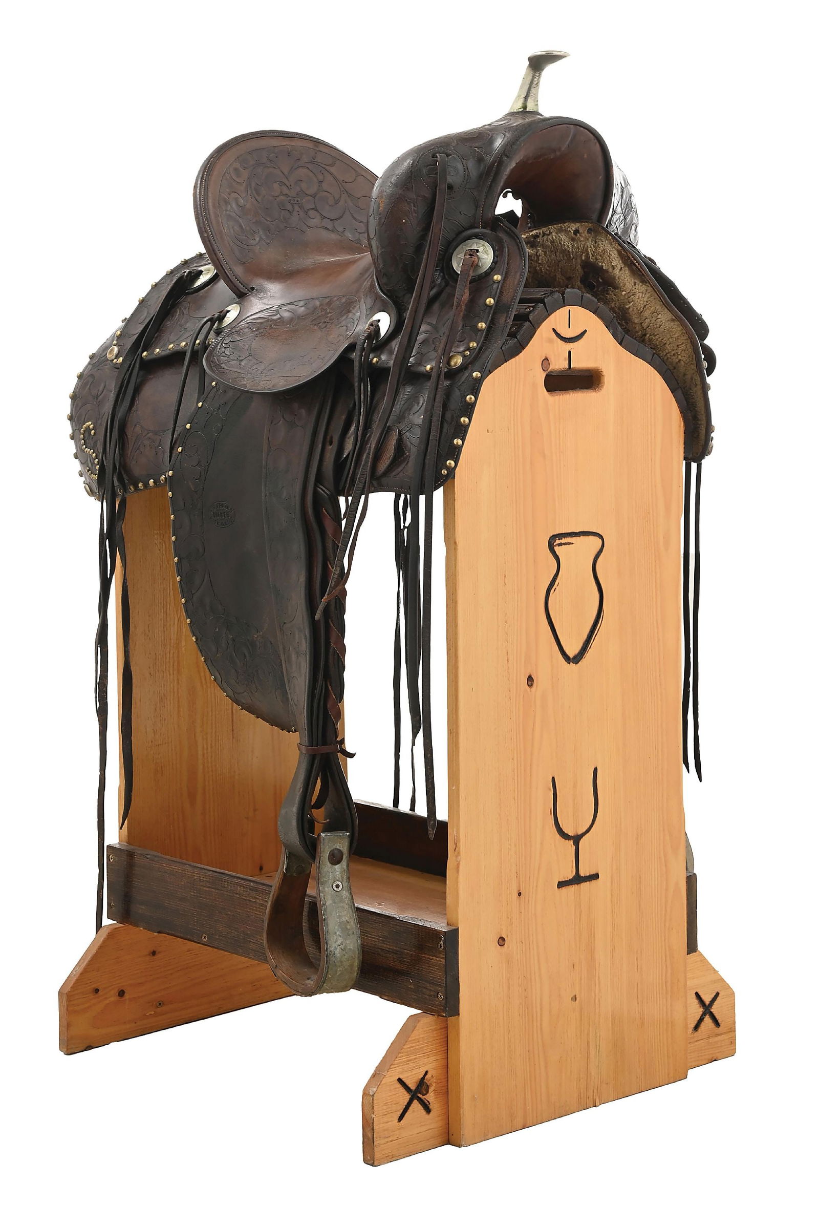 A DECORATIVE STUDDED R. T. FRAZIER SADDLE: R. T. Frazier saddle from Pueblo, Colorado, with added studding and decorations. Initials on the corners. Saddle started as very nice floral tooled solid seat saddle with a 6" cantle and a 15" seat. I