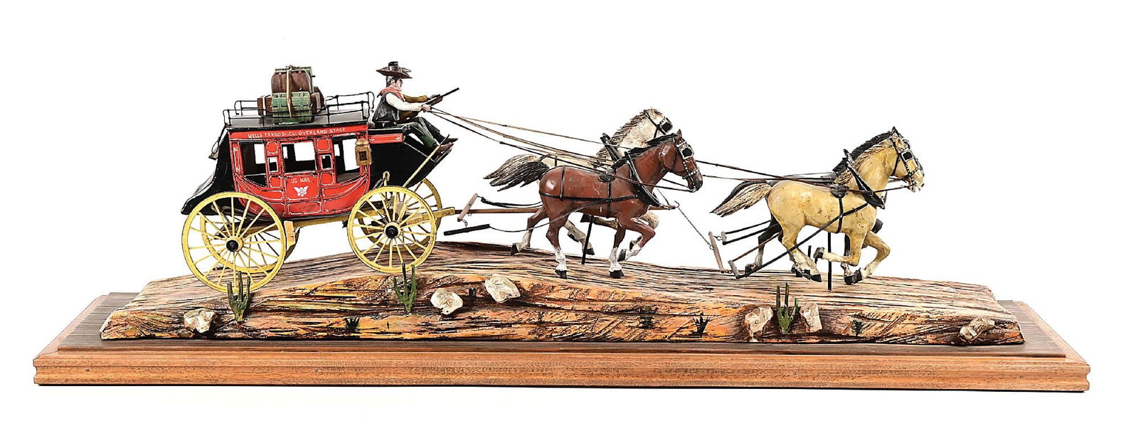 OSCAR CORTES WELLS FARGO OVERLAND STAGECOACH: Wood carving by Oscar M. Cortes of California. A detailed depiction of a 6-up team of horses pulling a Wells Fargo Overland stage over desert terrain. The model is 8 1/2" tall, 37" long, 11 1/2" wide