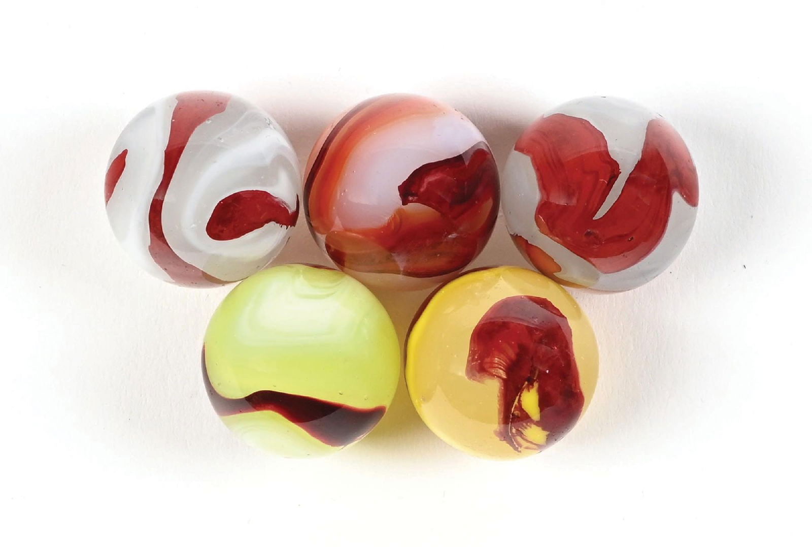 LOT OF 5: AKRO AGATE OXBLOOD MARBLES: All 3/4" diam. Lot includes one Carnelian Oxblood, two Silver Oxbloods, one Lemonade Oxblood, and one Egg Yolk Oxblood. Each marble has some fleabites. Condition: (8.7 - 8.9). Dimensions: