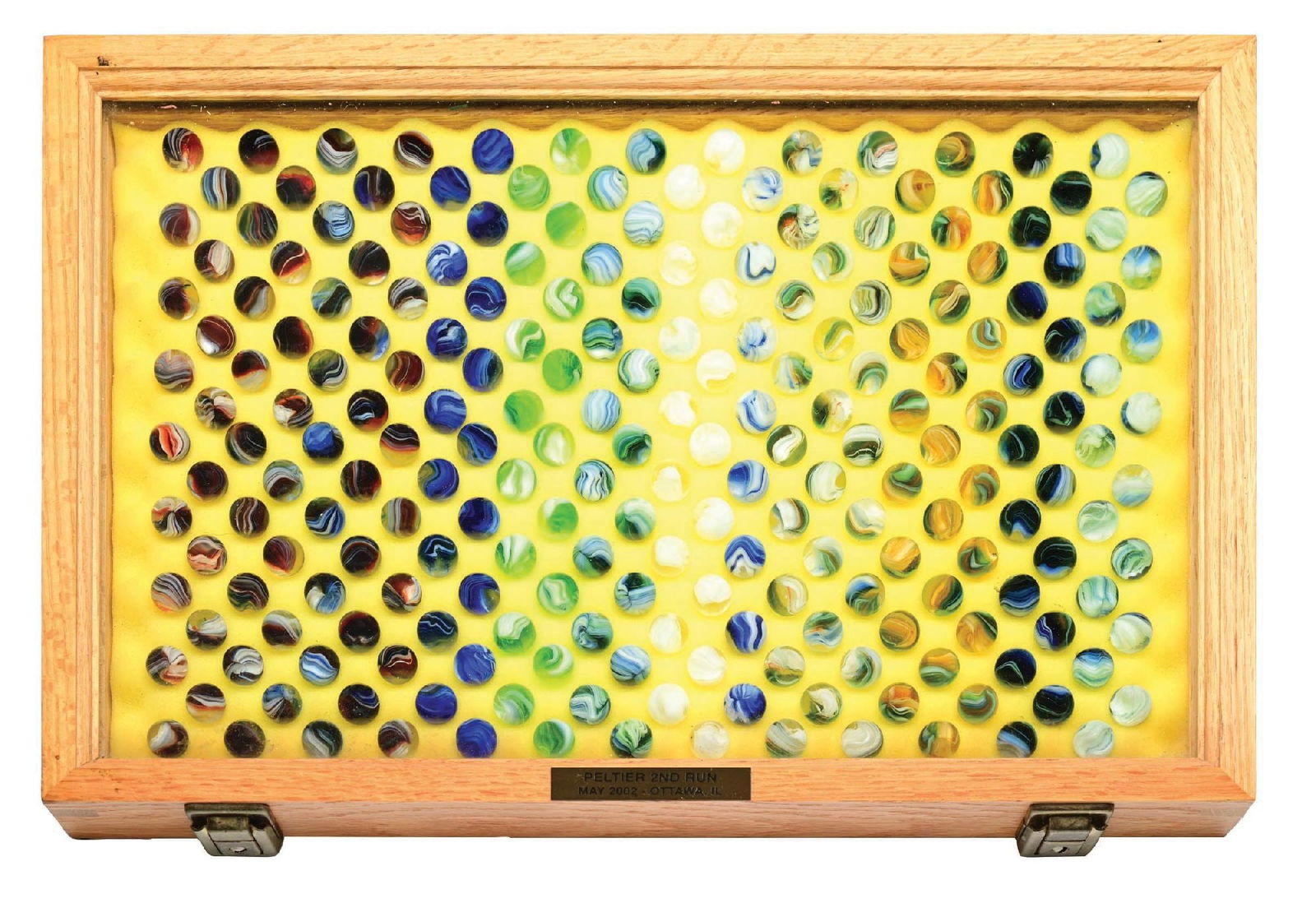 GROUP OF 221 PELTIER SECOND RUN 2002 MARBLES IN WOOD CASE: 5/8" diam. Group includes reds, blues, green, whites, and orange. Reminiscent of Akro Sparklers. Case included. Condition: Dimensions: Case: 18" x 12" x 1 - 7/8".