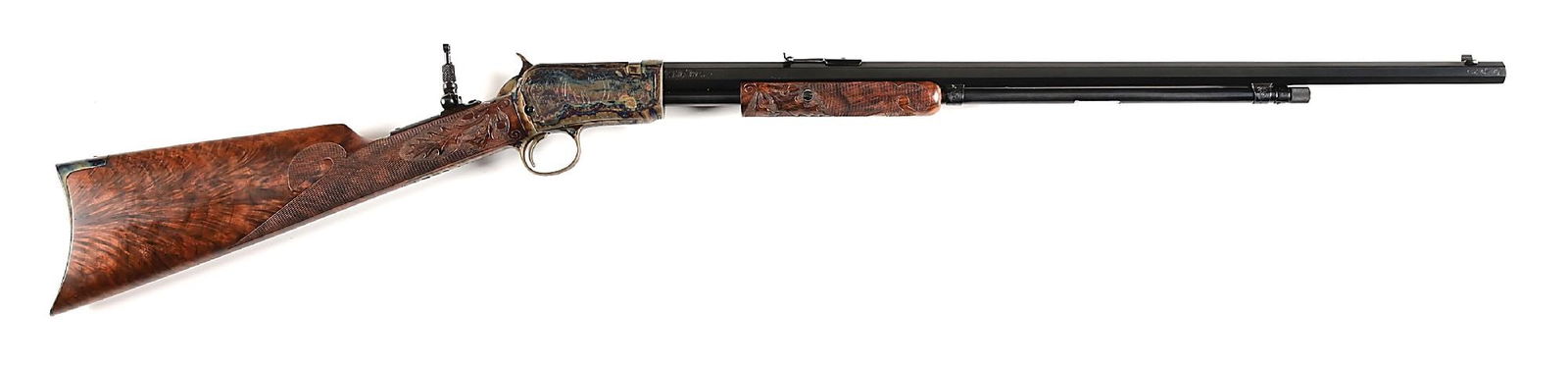 (C) NICK KUSMIT ENGRAVED WINCHESTER MODEL 1890 .22 WRF SLIDE ACTION RIFLE.: Blued finished octagon barrel with case colored receiver. Engraved with vignettes of deer in a woodlands scenes with scroll and foliate. Elegantly checkered and carved stocks with a Germanic oak leaf