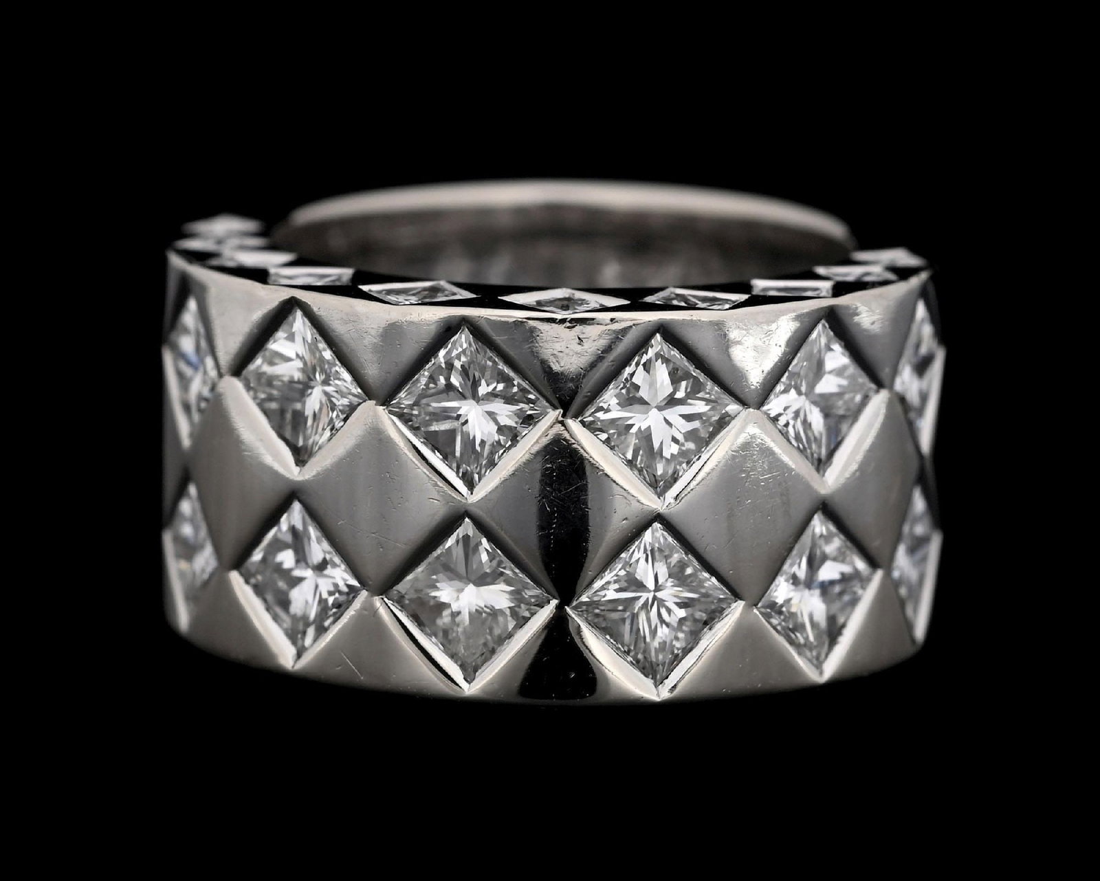 CHANEL 18K WHITE GOLD DIAMOND RING: Ladies' 18k white gold Chanel wide diamond ring/band consisting of 34 princess cut natural diamonds with a total weight of 4.50cts. Gross weight is 15.9 grams. Finger size 5-1/2. Width measures 11mm. 